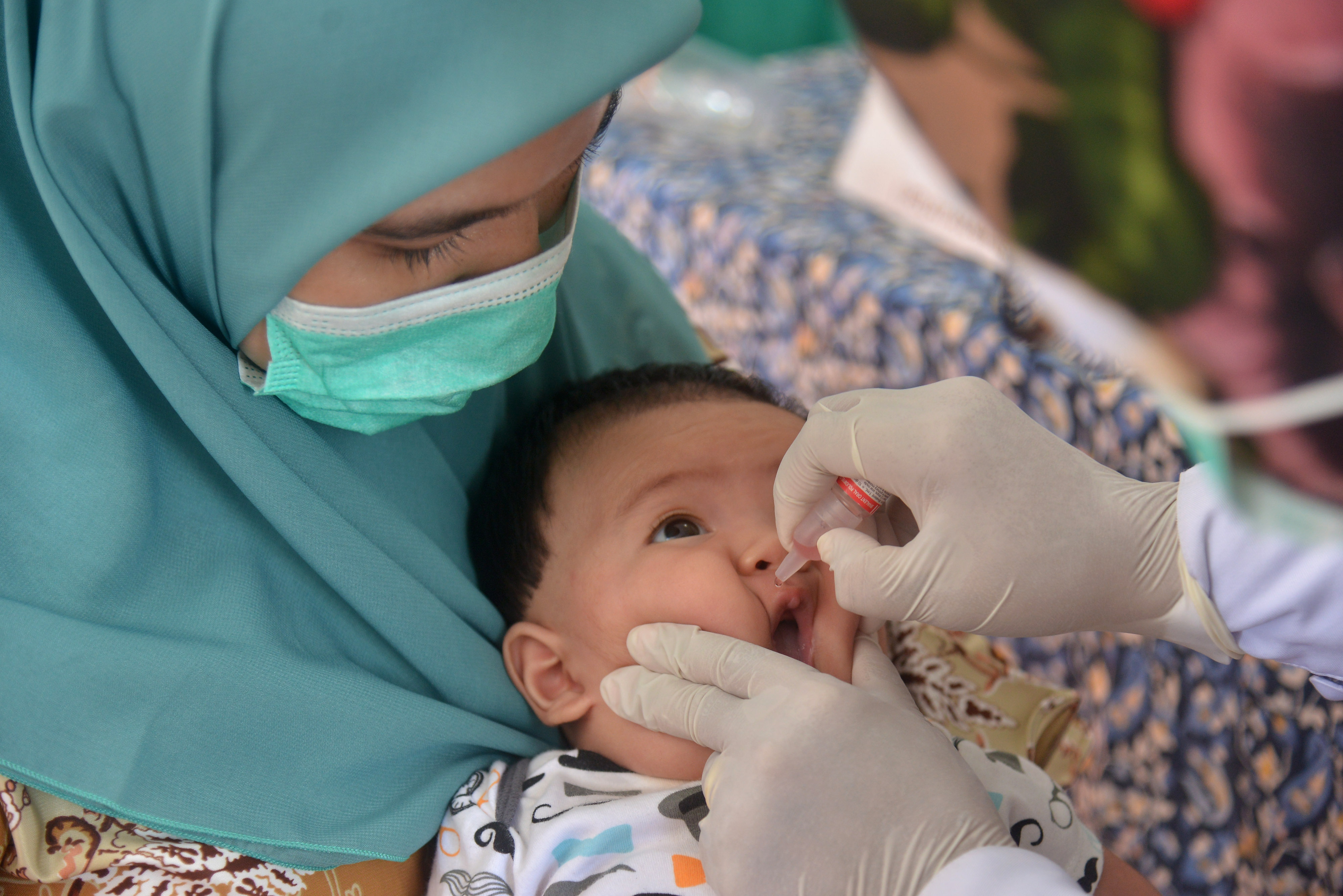  Petugas memberikan vaksin polio saat berlangsung imunisasi di Posyandu Kuta Alam, Banda Aceh, Aceh,  Selasa (2/2/2021