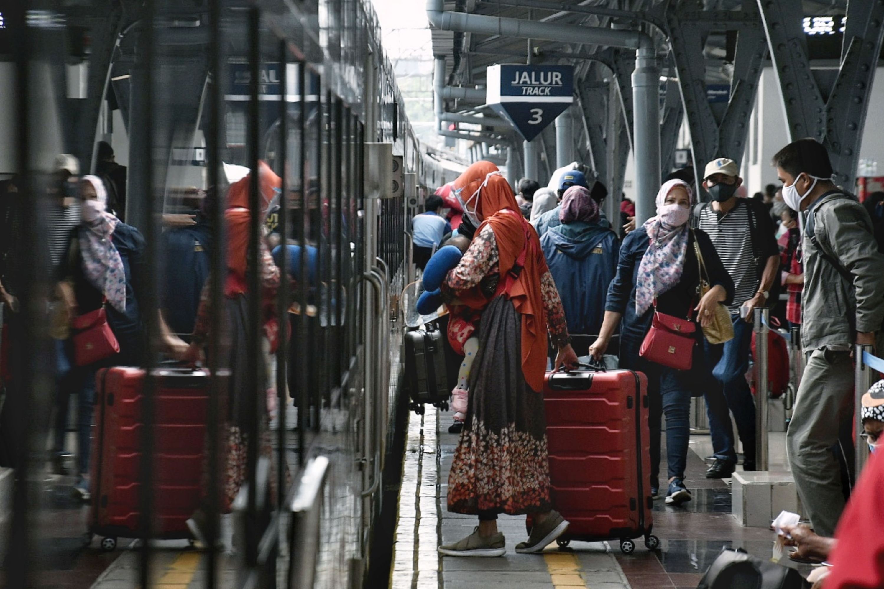 Penumpang menaiki kereta api jarak jauh di Stasiun Pasar Senen, Jakarta, Minggu (11/4).