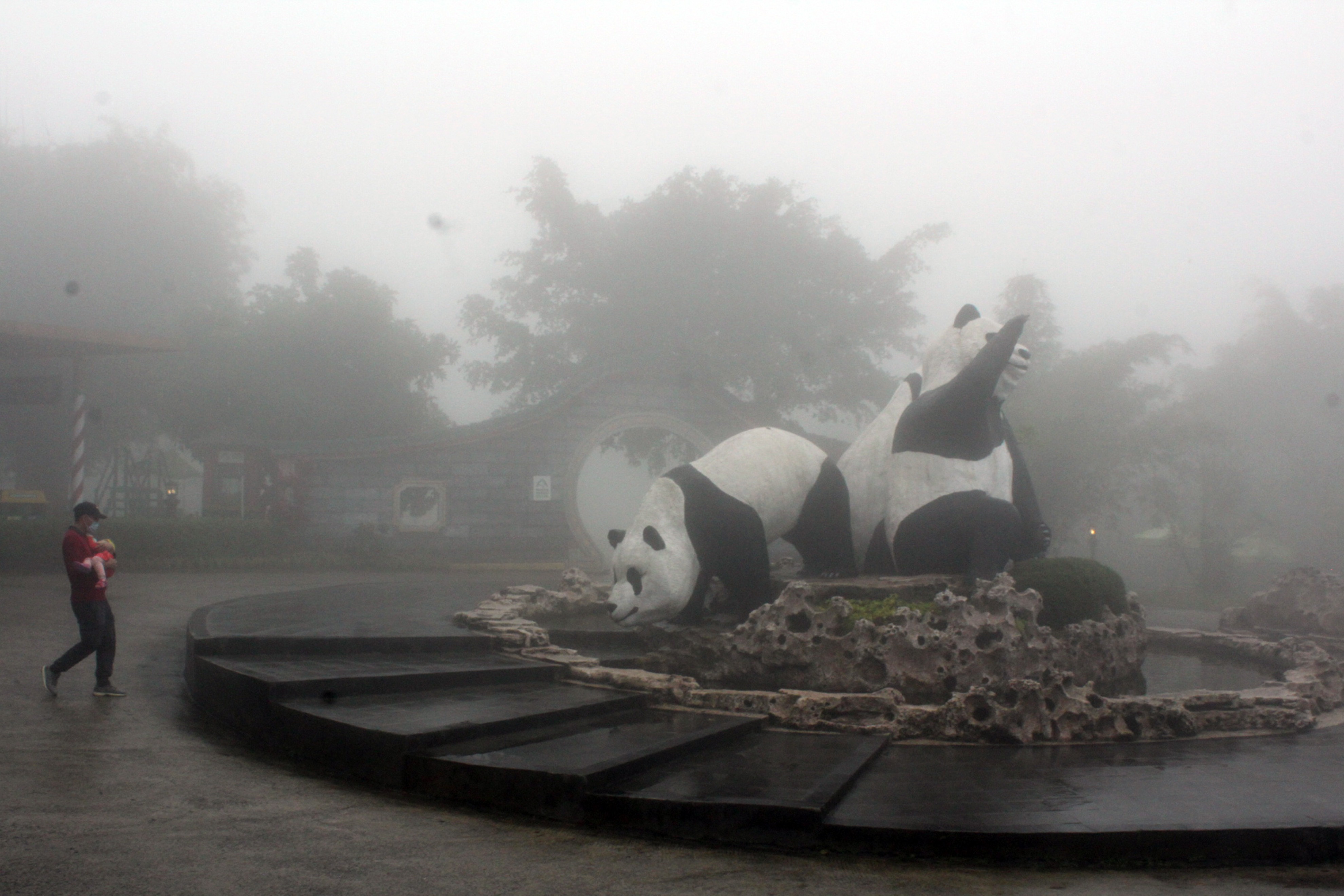 Pengunjung berjalan saat kabut turun di Istana Panda, Taman Safari Indonesia, Cisarua, Kabupaten Bogor, Jawa Barat, beberapa waktu lalu.