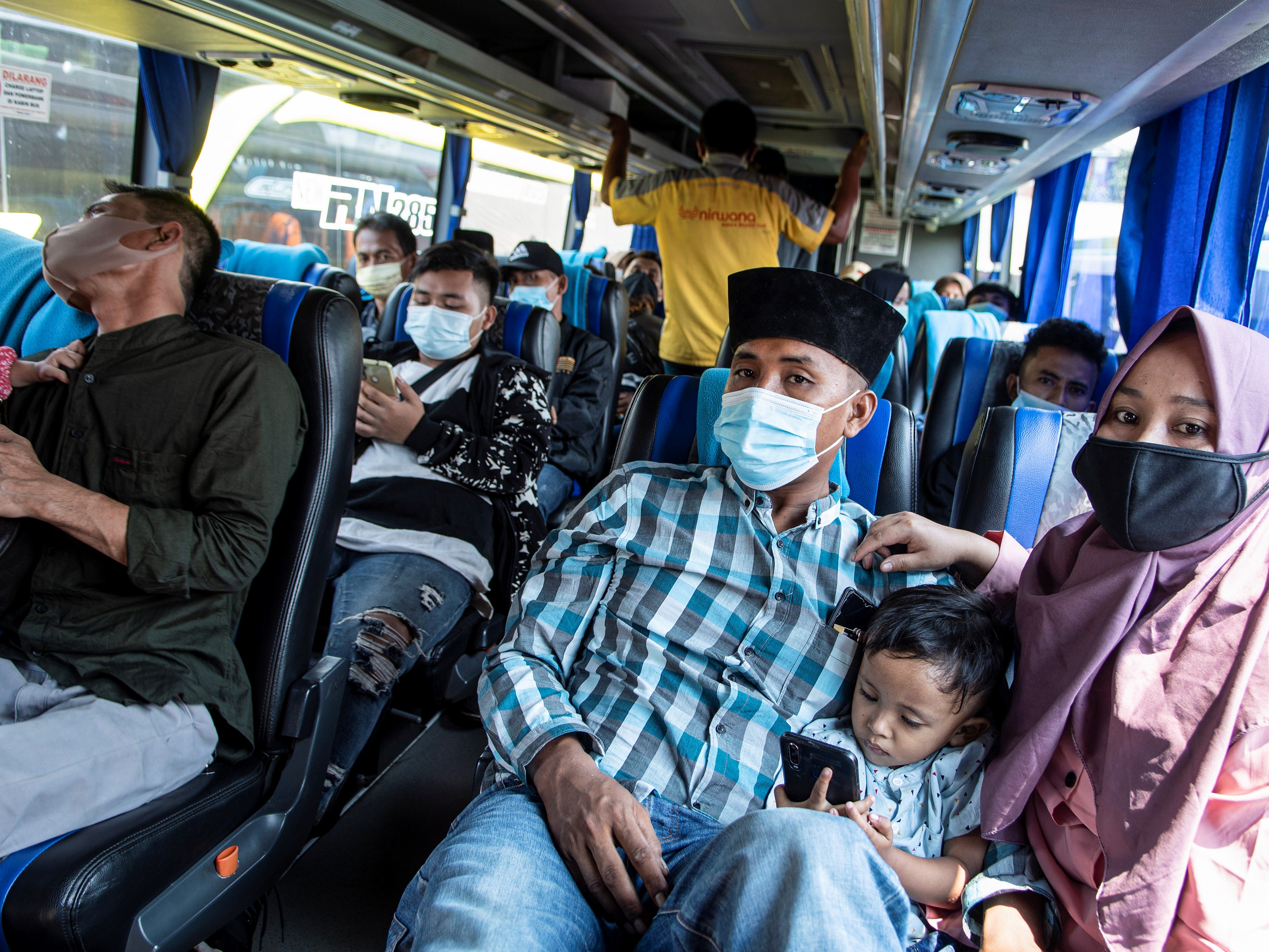 Sejumlah penumpang dengan mengenakan masker duduk di dalam bus di Terminal Kalideres, Jakarta Barat, Senin (26/4).