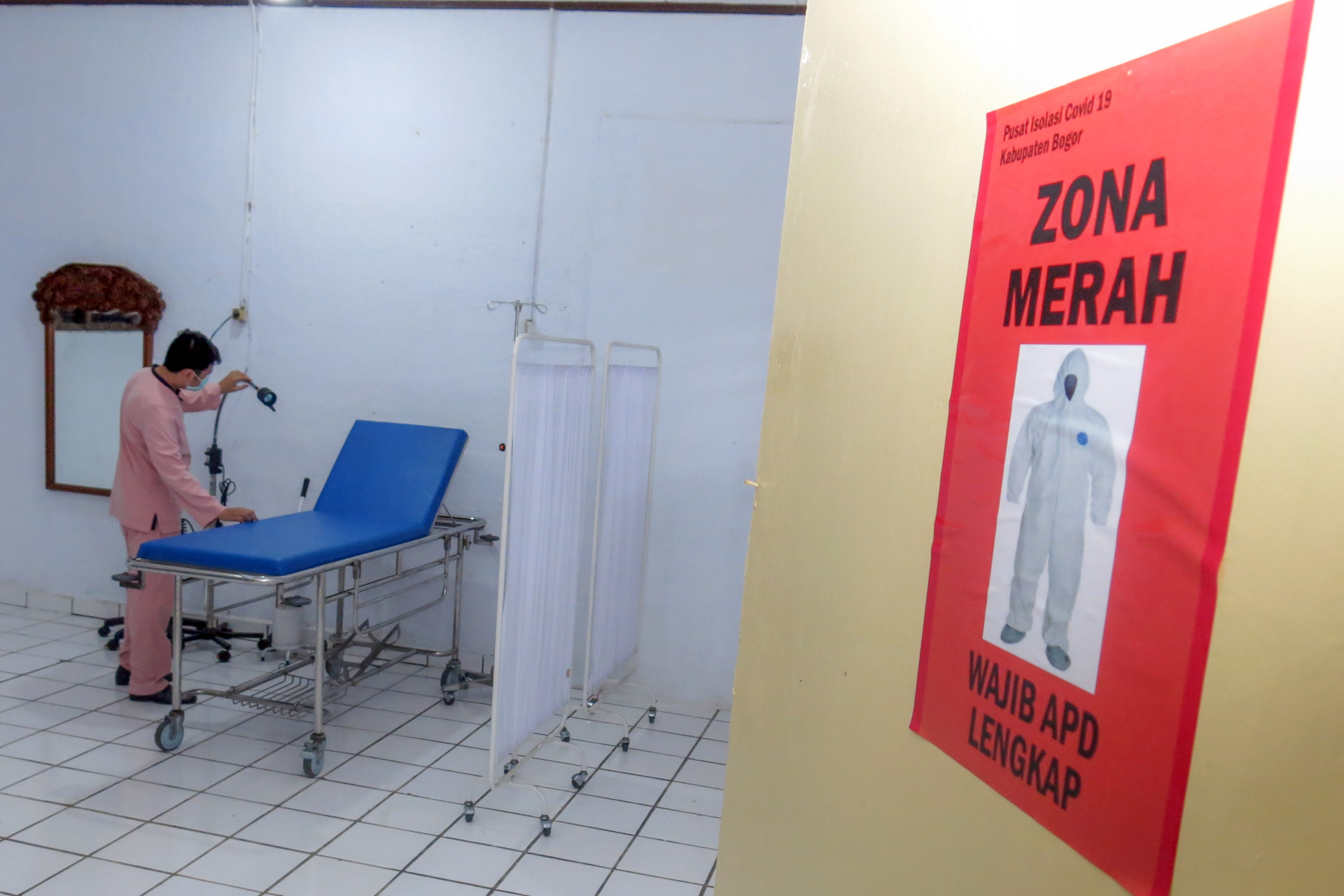 Seorang tenaga medis menata ruang pemeriksaan kesehatan untuk pasien covid-19 OTG di Wisma Cibogo, Puncak, Bogor, Jabar, bebeapa waktu lalu.