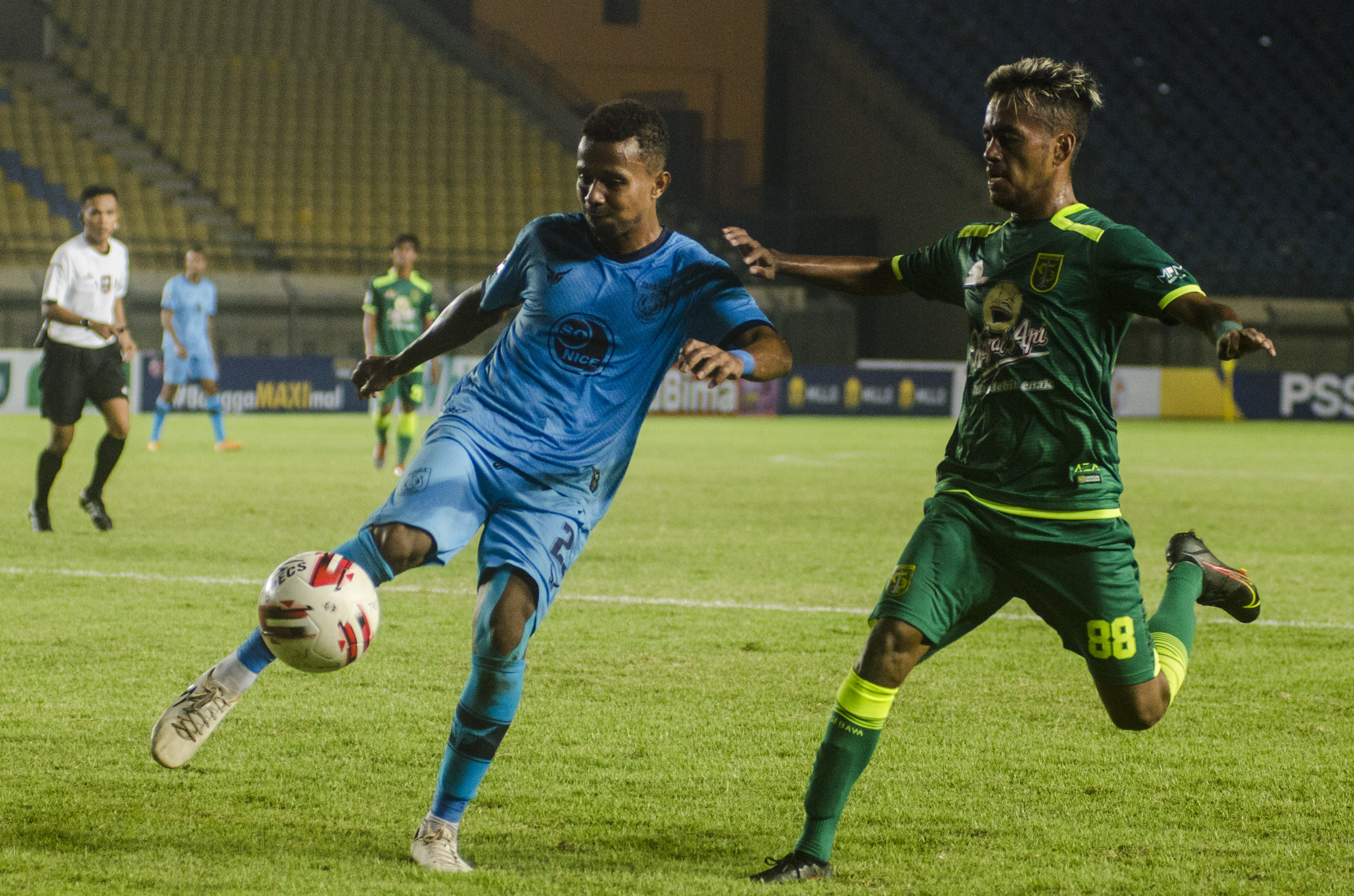 Pemain Persebaya  Alwi Slamat (kanan) berebut bola dengan pemain Persela Lamongan F. Womsiwor pada laga lanjutan Grup C Piala Menpora.