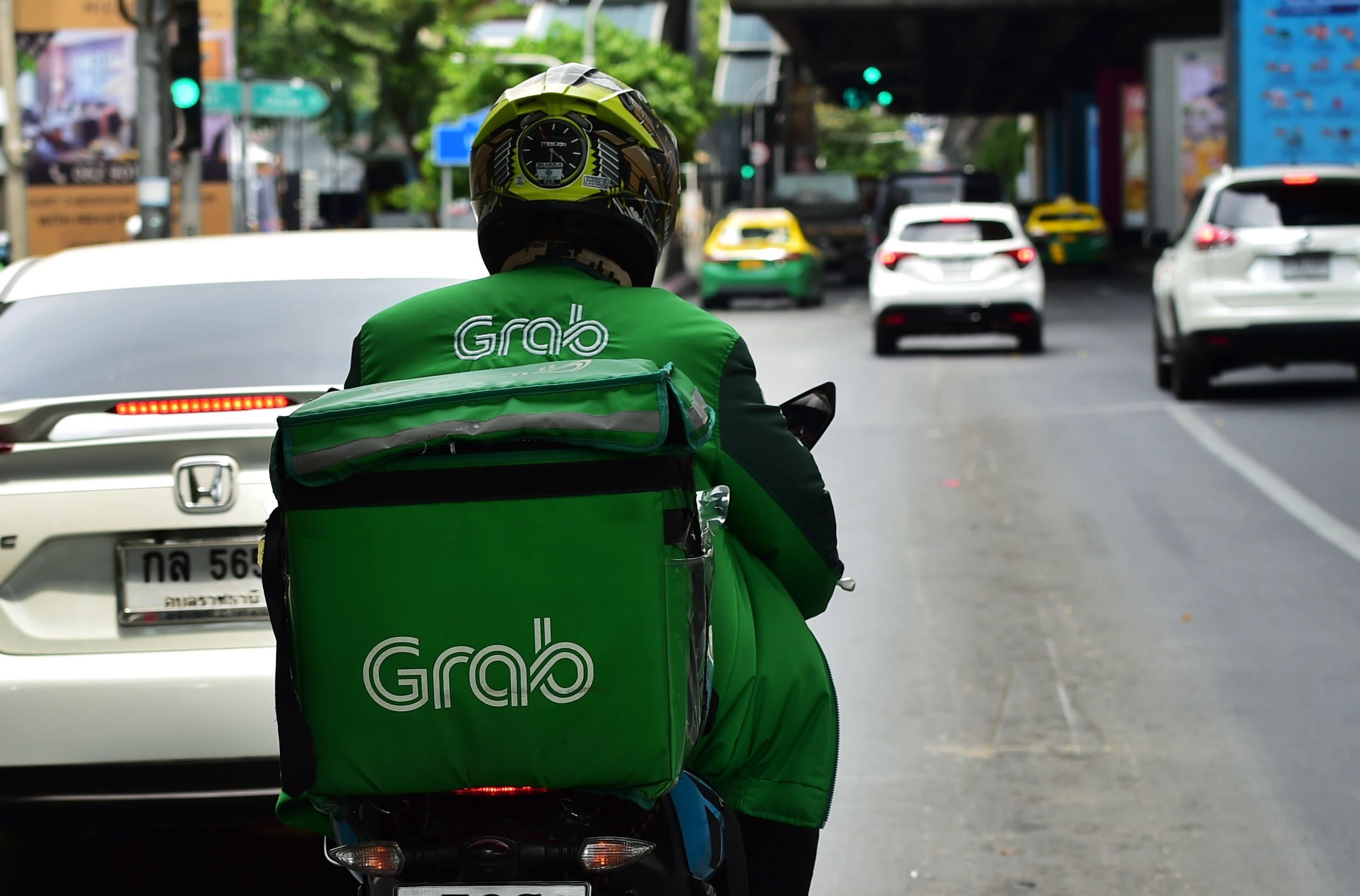 Ilustasi driver Grab yang mengantarkan makanan.