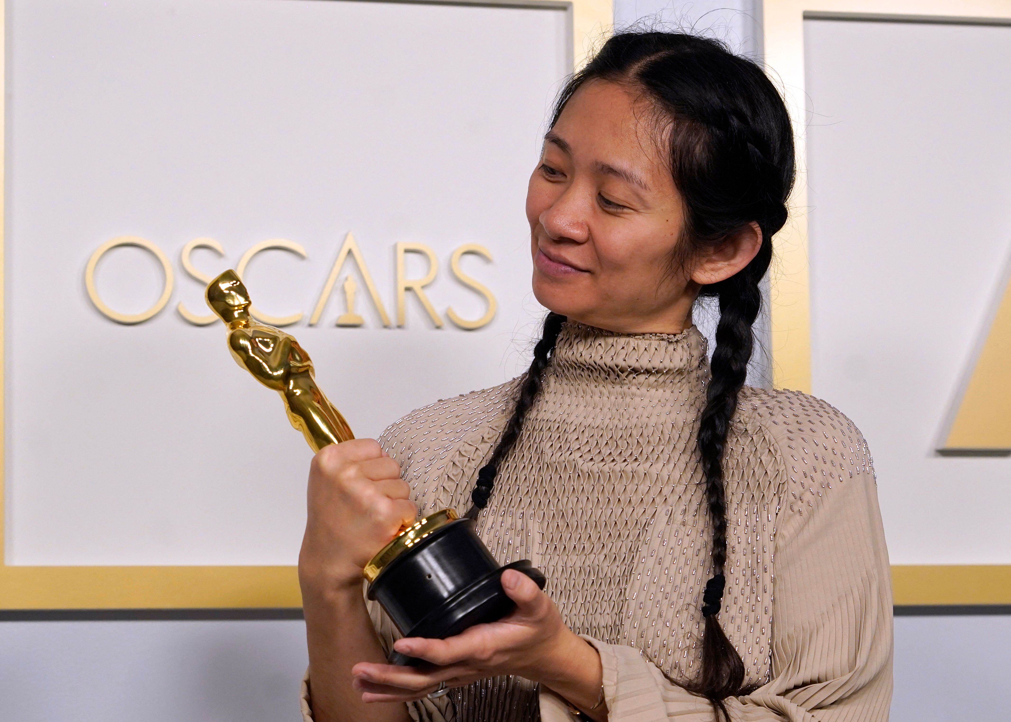 Sutradara Chloe Zhao memengan Piala Oscar yang dimenangkannya untuk film Nomadland.