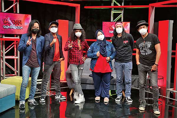 Perawat yang mendedikasikan dirinya sebagai petugas ambulans, Sri Mulyati (ketiga dari kanan), berfoto bersama grup band Slank.  