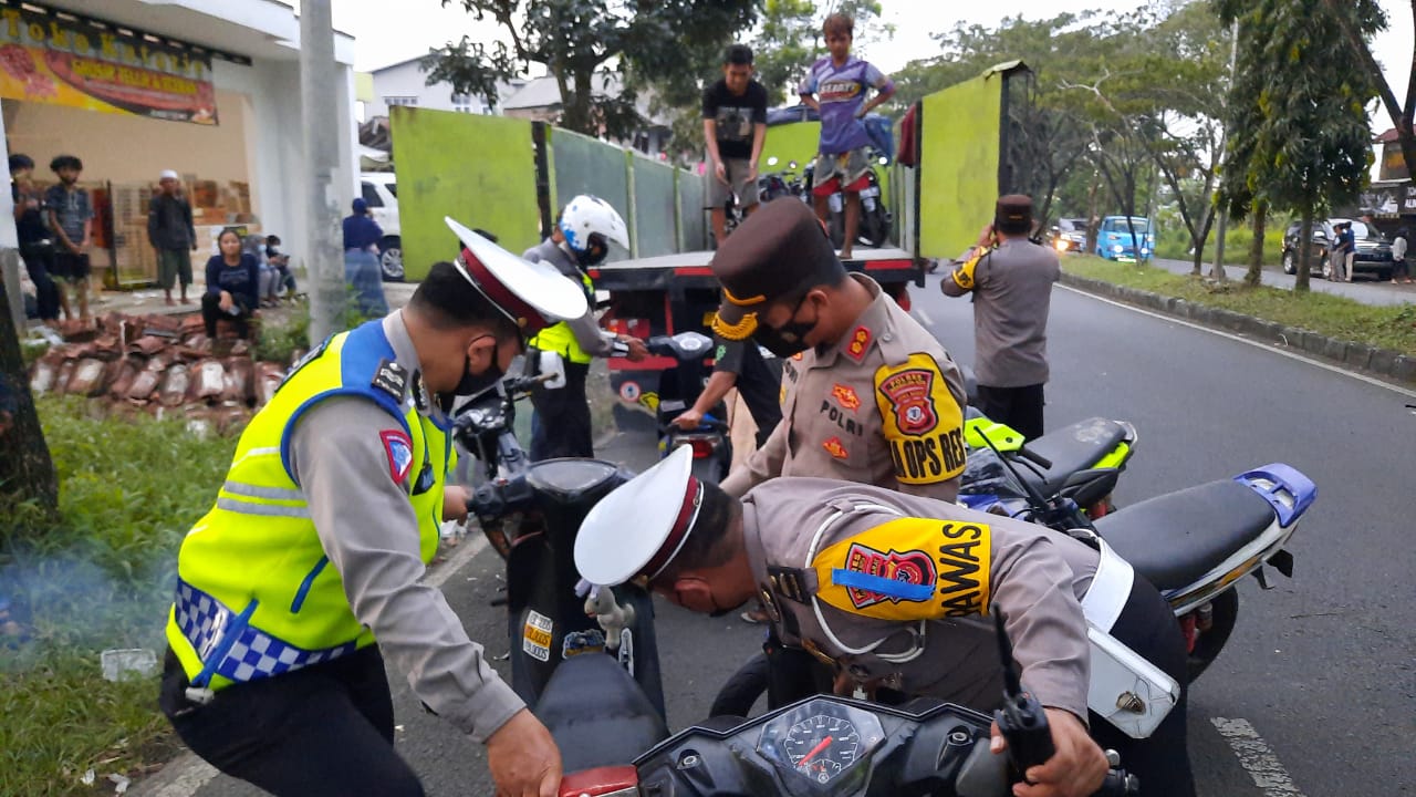 Petugas kepolisian Polres Tasikmalaya Kota mengangkut sepada motor yang dipakai untuik balapan liar, Jumat (16/4/2021).