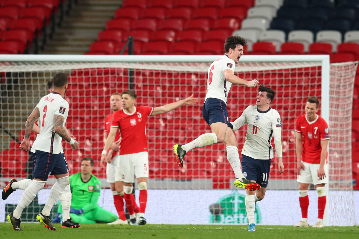 Bek Inggris, Harry Maguire (lompat) merayakan gol yang dicetak ke gawang Polandia dalam laga kualifikasi Piala Dunia 2022, Kamis (1/4). 