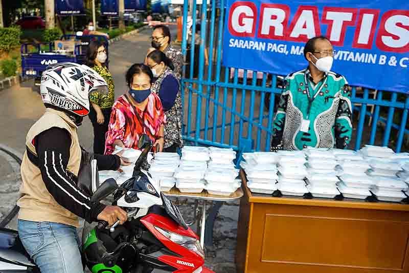 Relawan memberikan makanan gratis kepada masyarakat. 