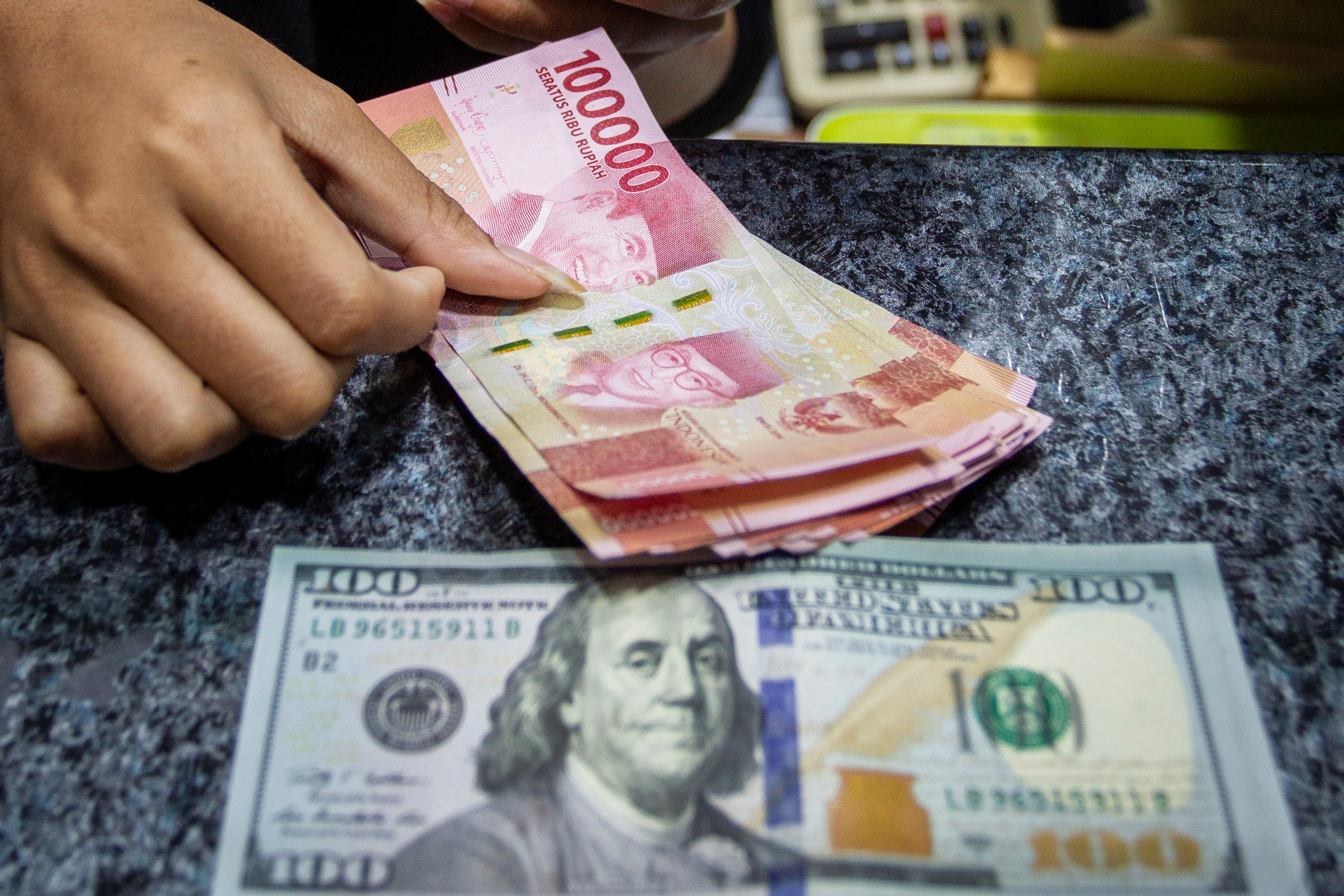 Karyawan menghitung uang di salah satu gerai penukaran uang asing di Jakarta, beberapa waktu lalu.