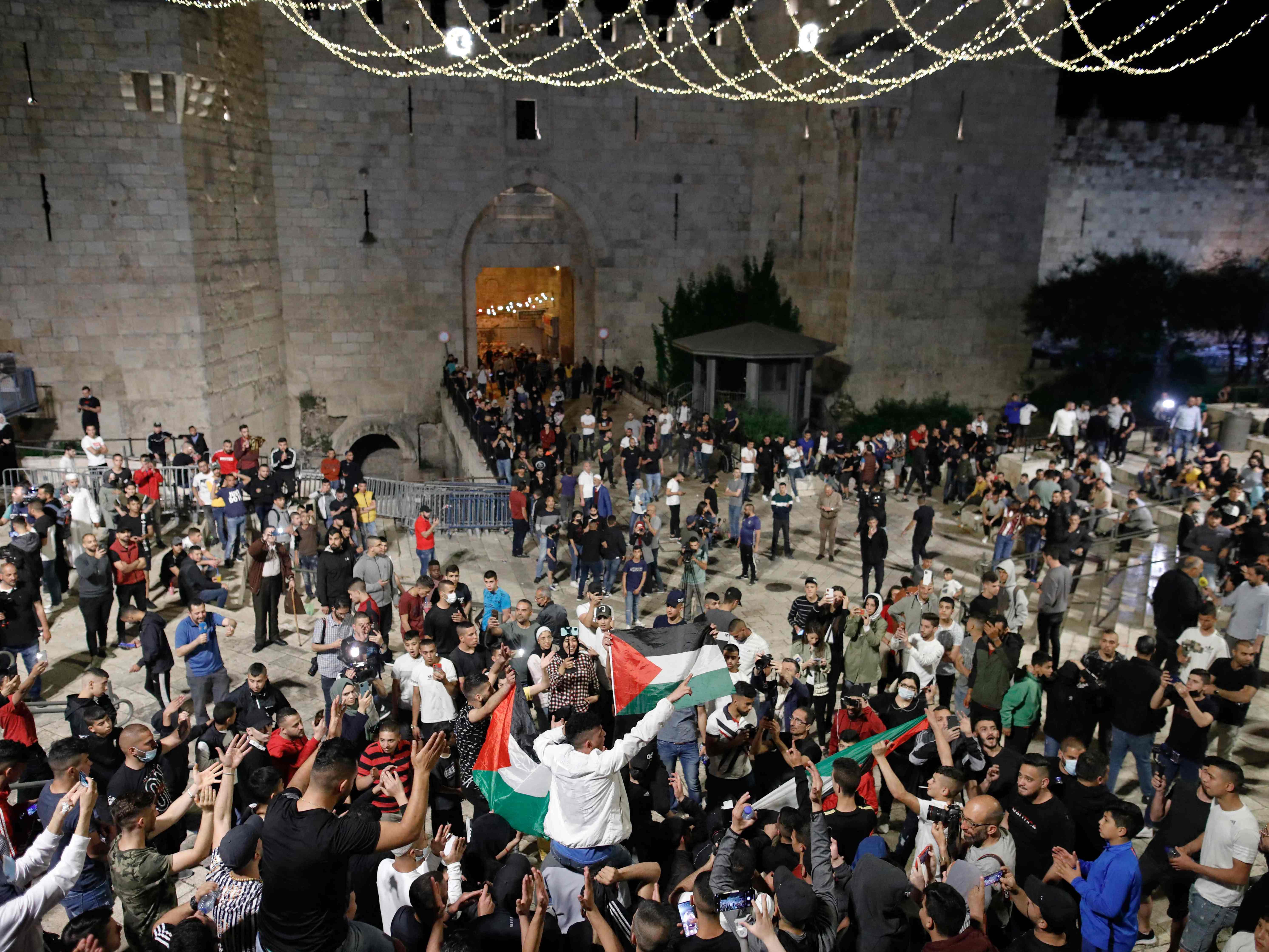 Pengunjuk rasa Palestina mengibarkan bendera nasional ketika berkumpul di dekat Gerbang Damaskus di Kota Tua Yerusalem, Minggu (25/4). 