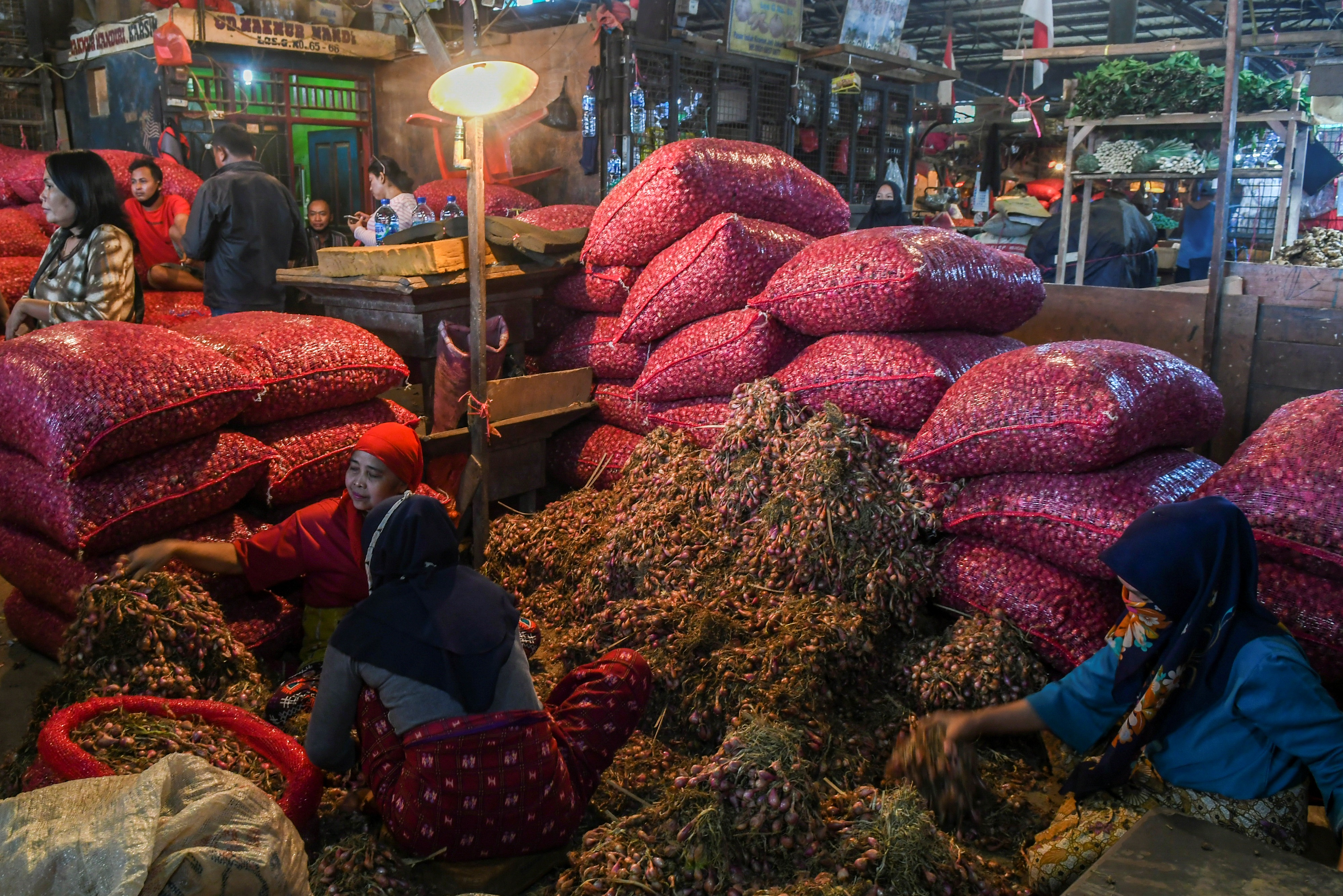 Pedagang menyortir bawang merah yang dijual di Pasar Induk Kramat Jati, Jakarta, Rabu (7/4).