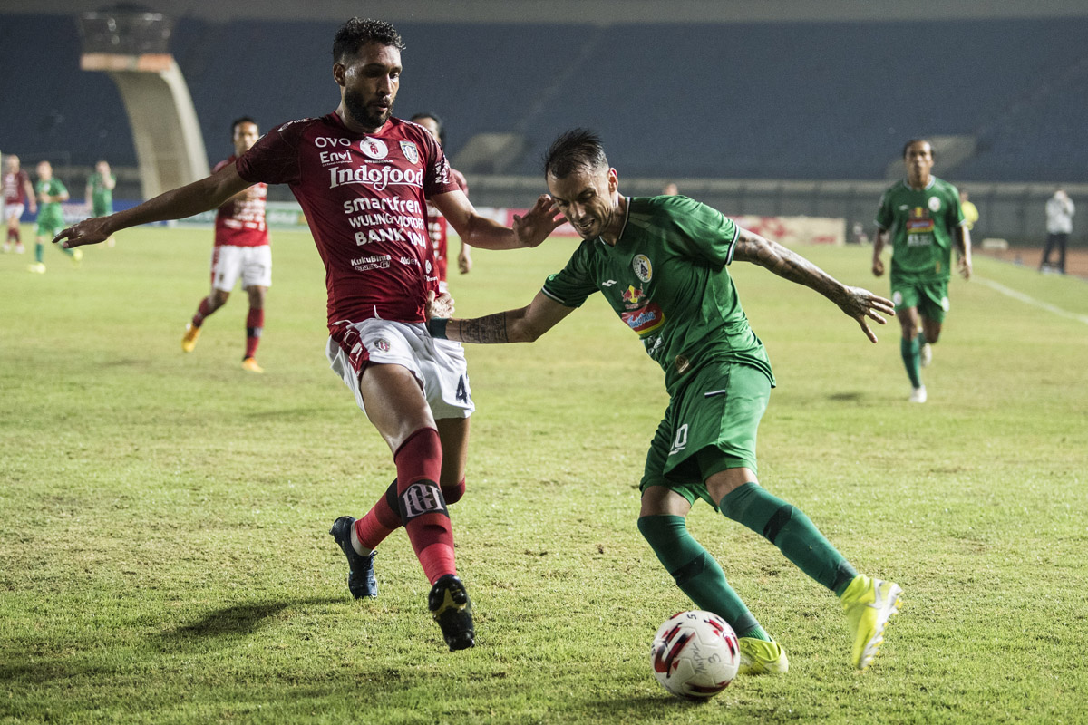 Pemain Bali United W. Pacheco (kiri) berusaha menghadang pemain PSS Sleman Nico Velez dalam perempat final Piala Menpora 2021, Senin (12/4).