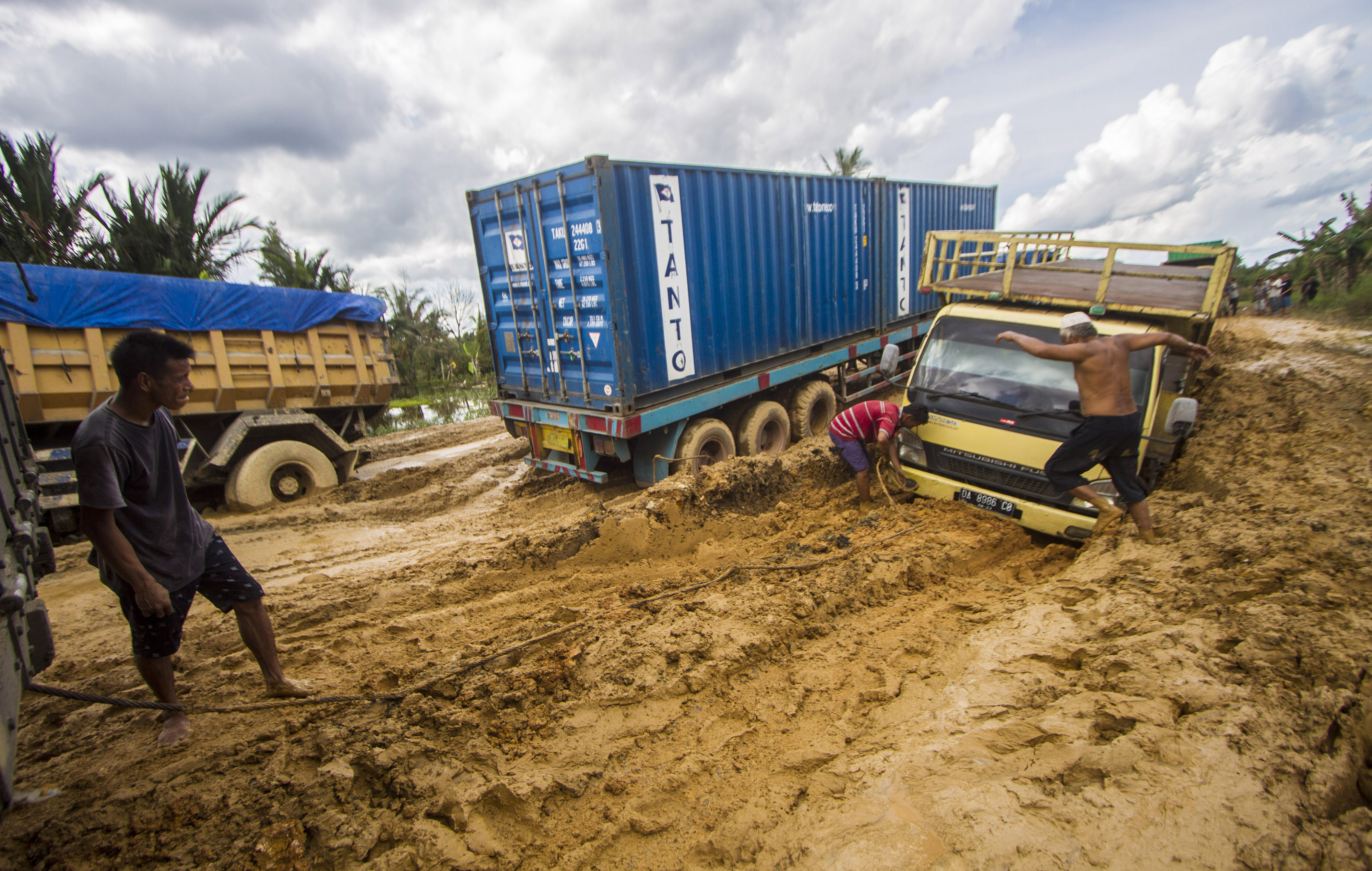 Sejumlah truk terperosok di Jln Gubernur Sarkawi yang rusak di Kecamatan Sungai Tabuk, Kabupaten Banjar, Kalimantan Selatan.