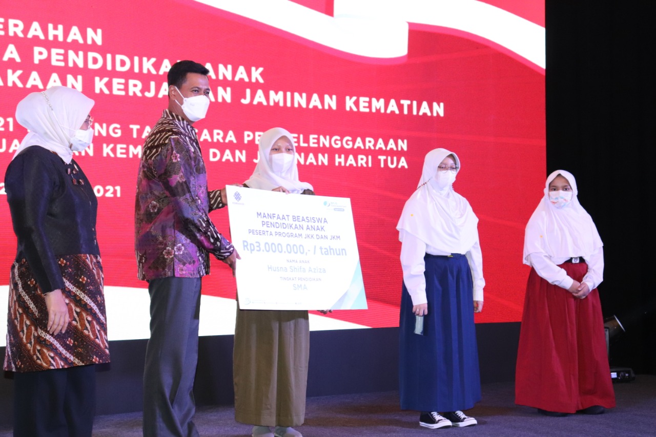 Menaker Ida Fauziyah (kiri) dan Dirut BPJAMSOSTEK Anggoro Eko Cahyo memberi manfaat beasiswa secara simbolis kepada anak dari ahli waris.   