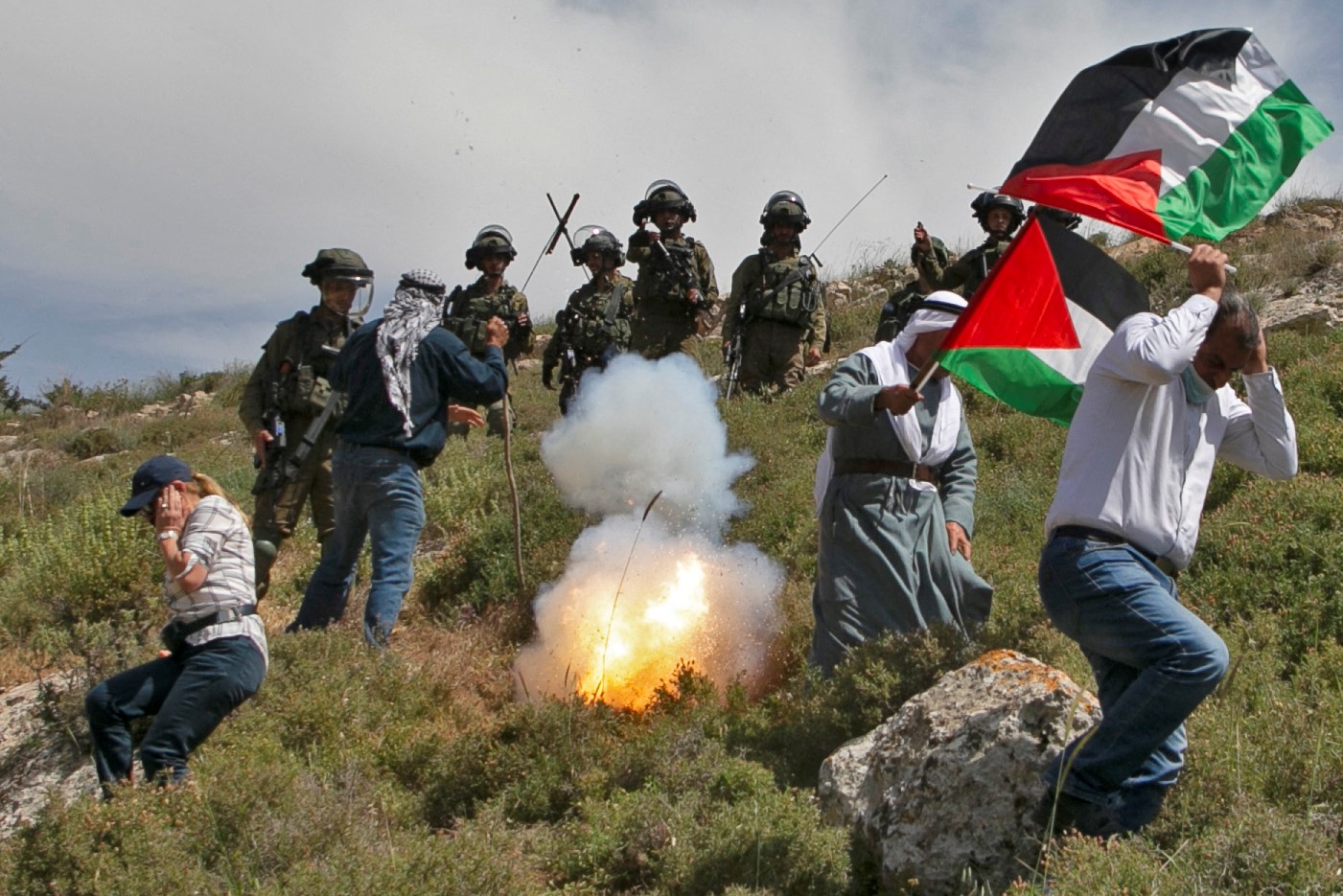 Pengunjuk rasa Palestina lari dari gas air mata yang ditembakkan pasukan keamanan Israel. Pendirian pos-pos Israel di tanah Palestina.