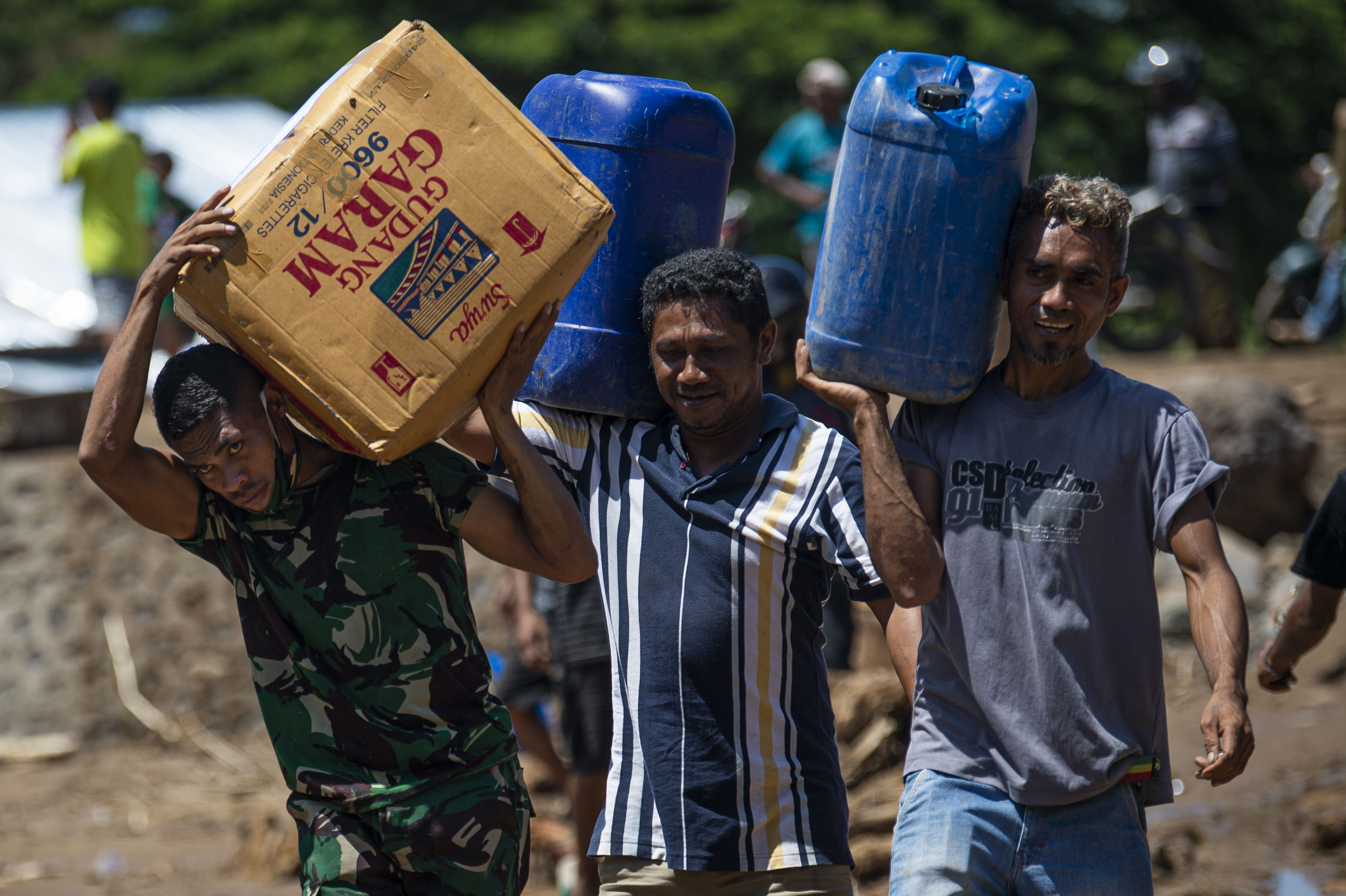 Sejumlah warga bergotong royong memindahkan bantuan logistik di Adonara Timur, Kabupaten Flores Timur,NTT, Rabu (7/4/2021).