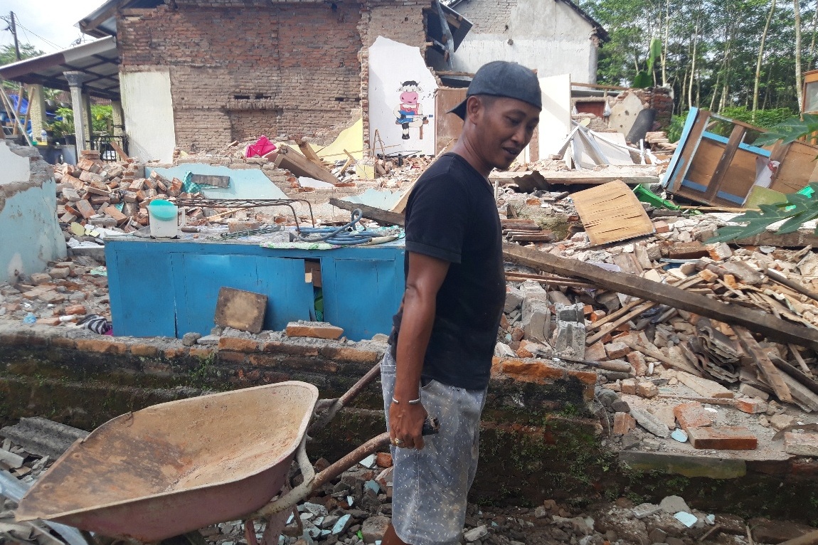 Korban bencana di Desa Majangtengah, Kecamatan Dampit, Malang, Agung Dwi Prayogo, membersihkan reruntuhan bangunan rumahnya, Rabu (14/4).