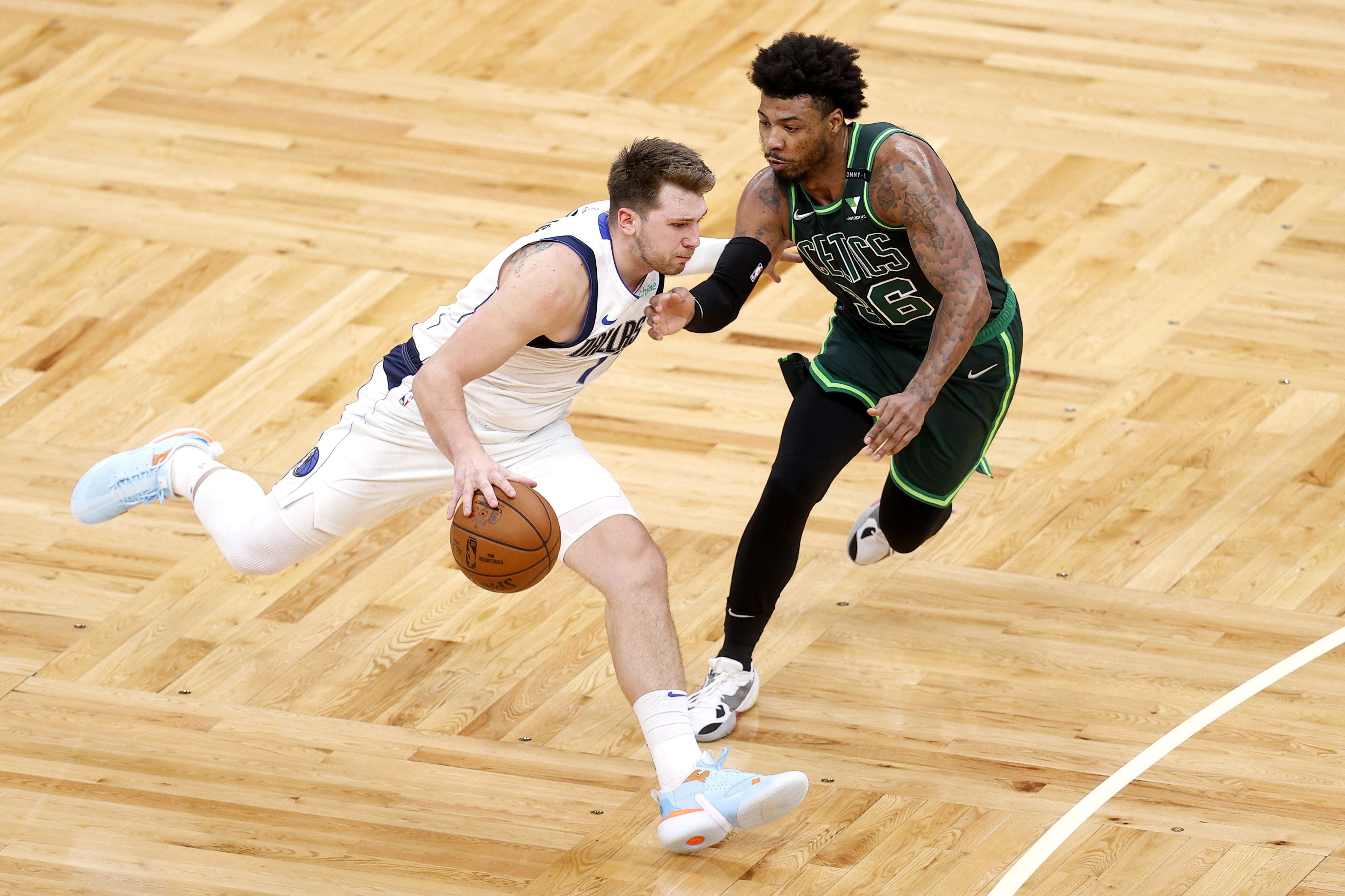 Pemain Dallas Mavericks Luka Doncic (kiri) menggiring bola dengan dihalangi Marcus Smart dari Boston Celtics.