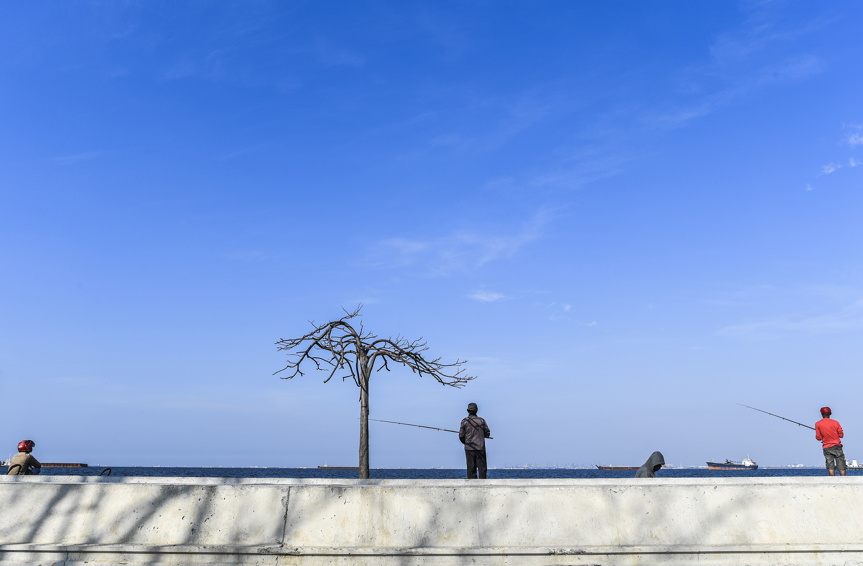 Cuaca cerah di pesisir Jakarta dimanfaatkan warga untuk memancing ikan di perairan Jakarta.