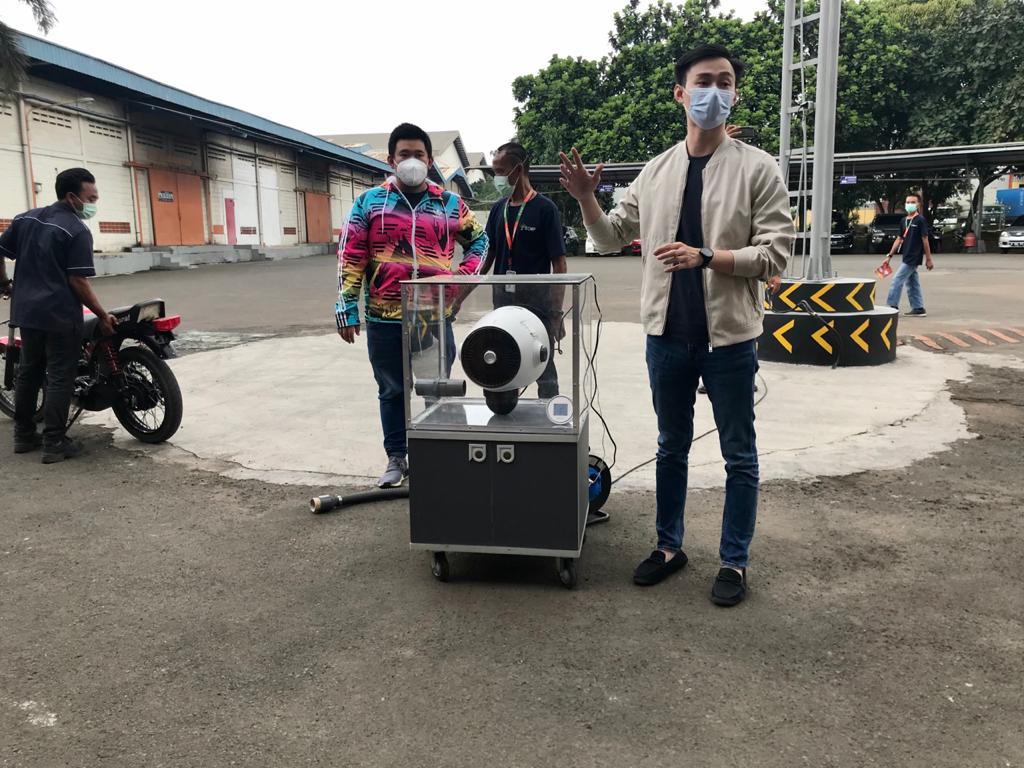 Brand Manager Trsna, Jeremy Surya, sedang mendemokan kerja perangkat air purifier buatannya yang mampu menjernihkan asap knalpot motor.