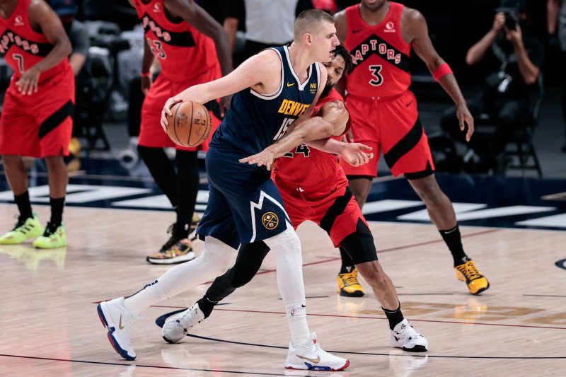 Center Toronto Raptors Khem Birch (24) berebut bola dengan center Denver Nuggets Nikola Jokic (15)