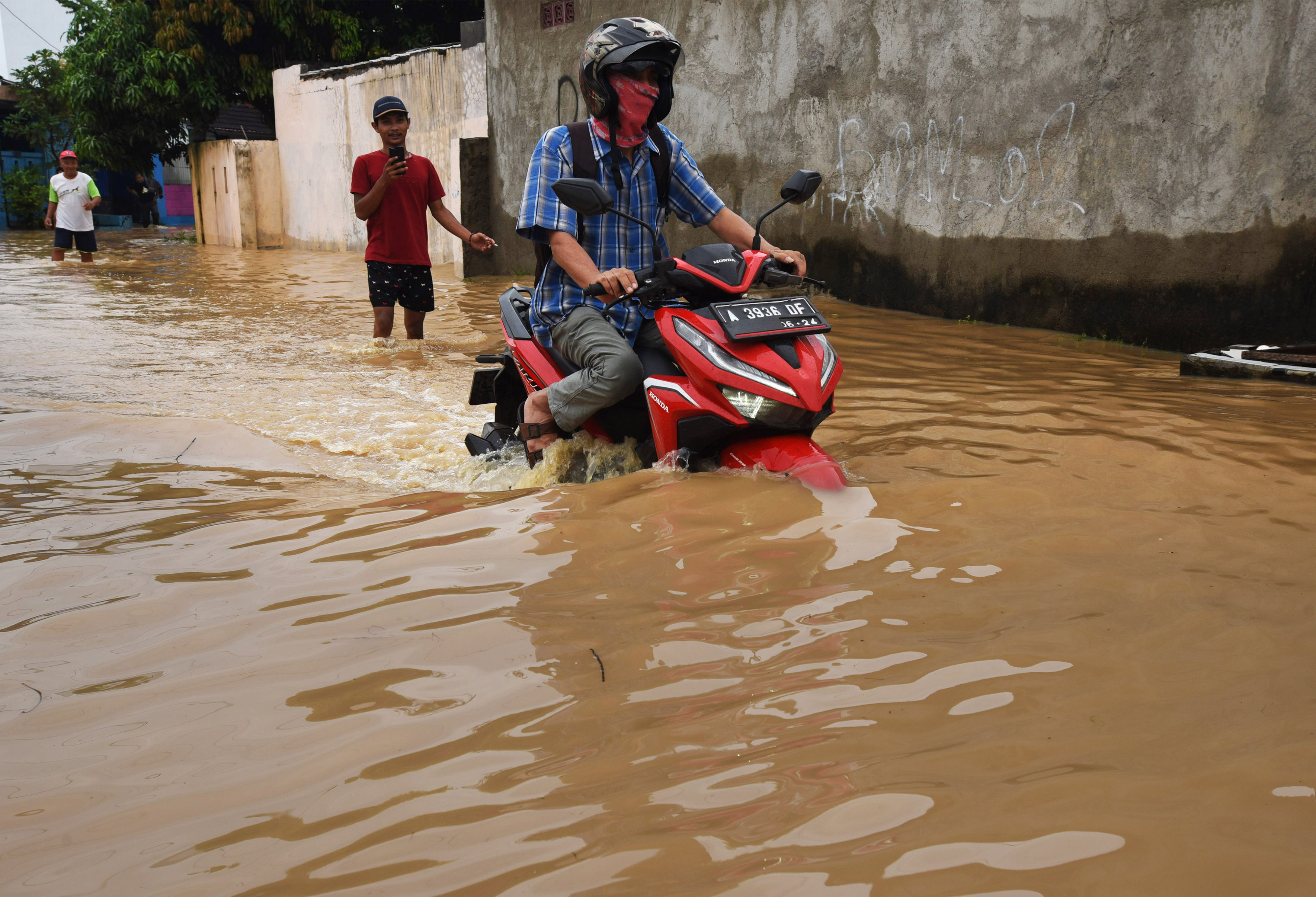 Pengendara sepeda motor menerobos banjir yang menutup jalan di Komplek Puri Cilegon, Margasana, Kramatwatu, Serang, Banten, Sabtu (3/4).