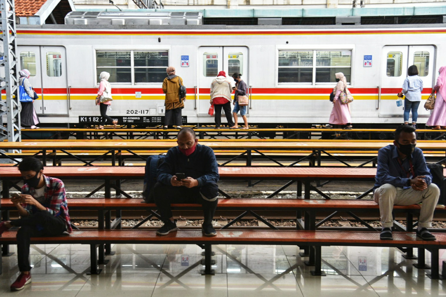 Penumpang menunggu kereta di stasiun Manggarai, Jakarta