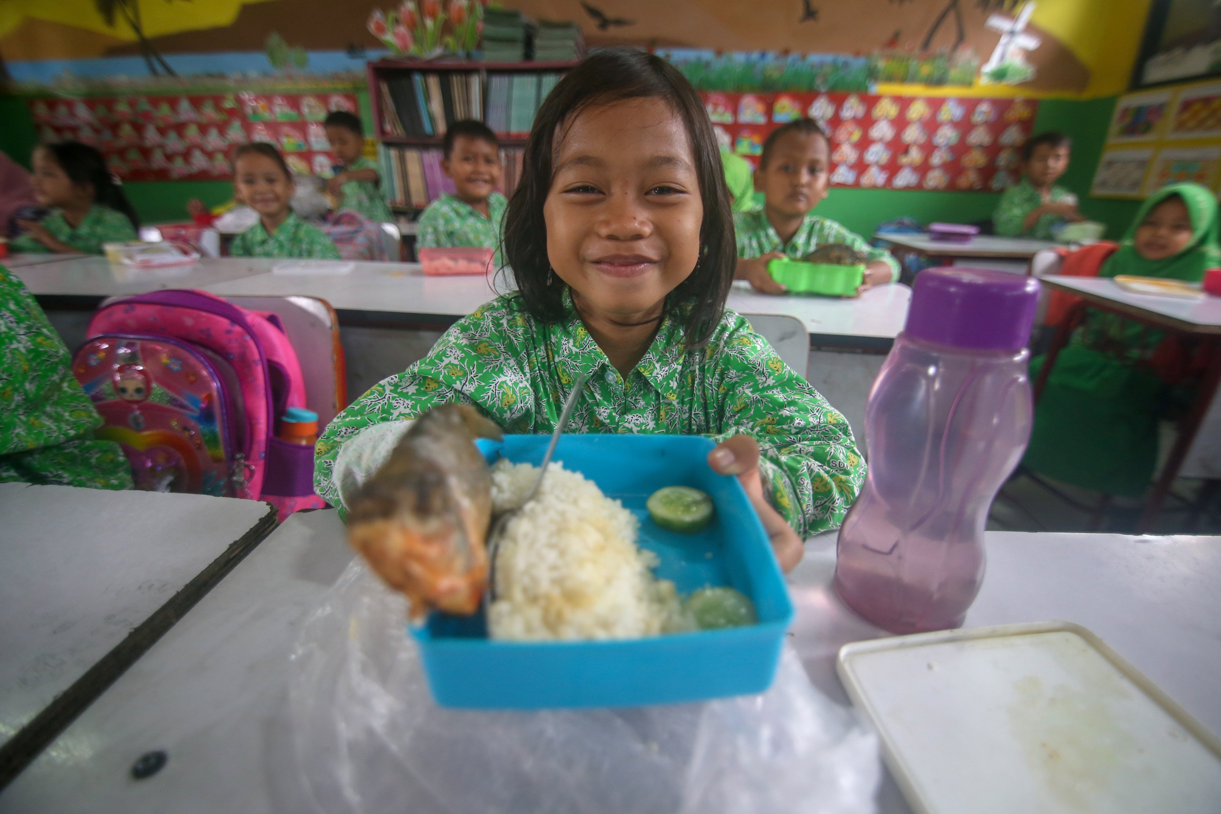 Siswa menunjukkan bekal ikan miliknya di SDN Tanah Tinggi 1, Kota Tangerang, Banten.