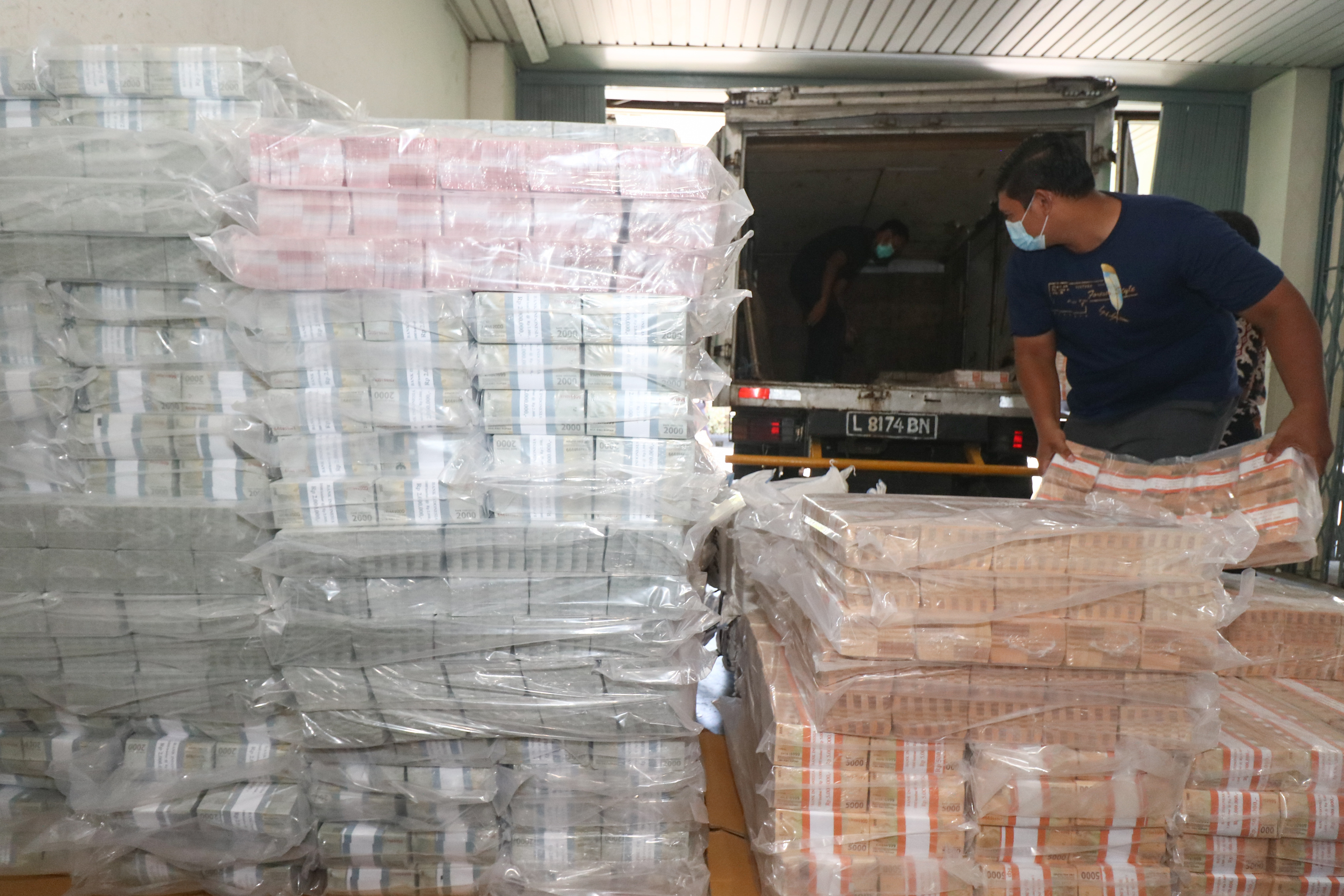  Petugas memasukkan bungkusan berisi uang kartal ke dalam truk pengangkut di Kantor Perwakilan Bank Indonesia Provinsi Jawa Timur.