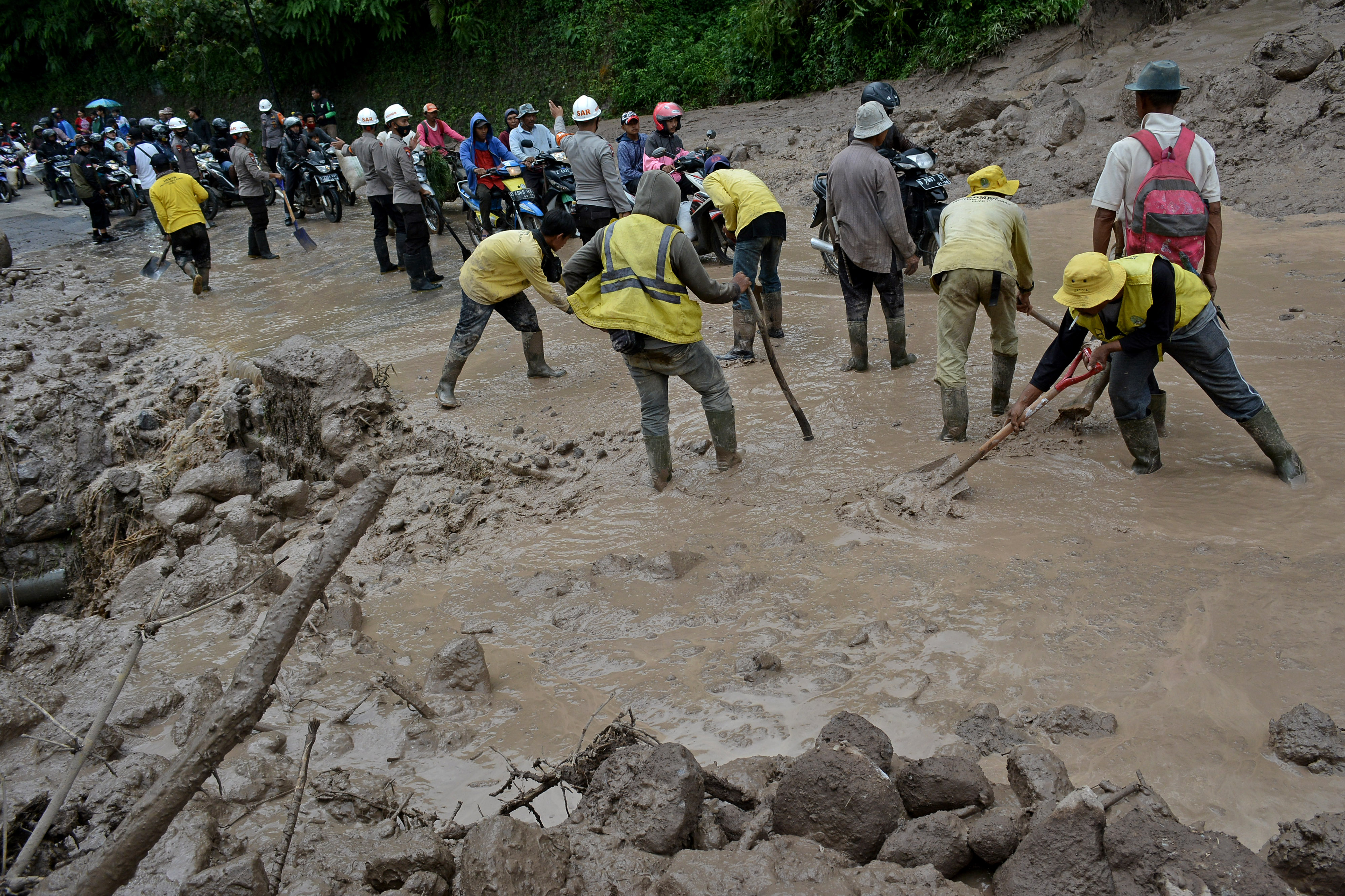 Pekerja membersihkan material lumpur akibat longsor di jalur alternatif Cijapati, Kadungora, Kabupaten Garut, Jawa Barat. (foto ilustrasi)