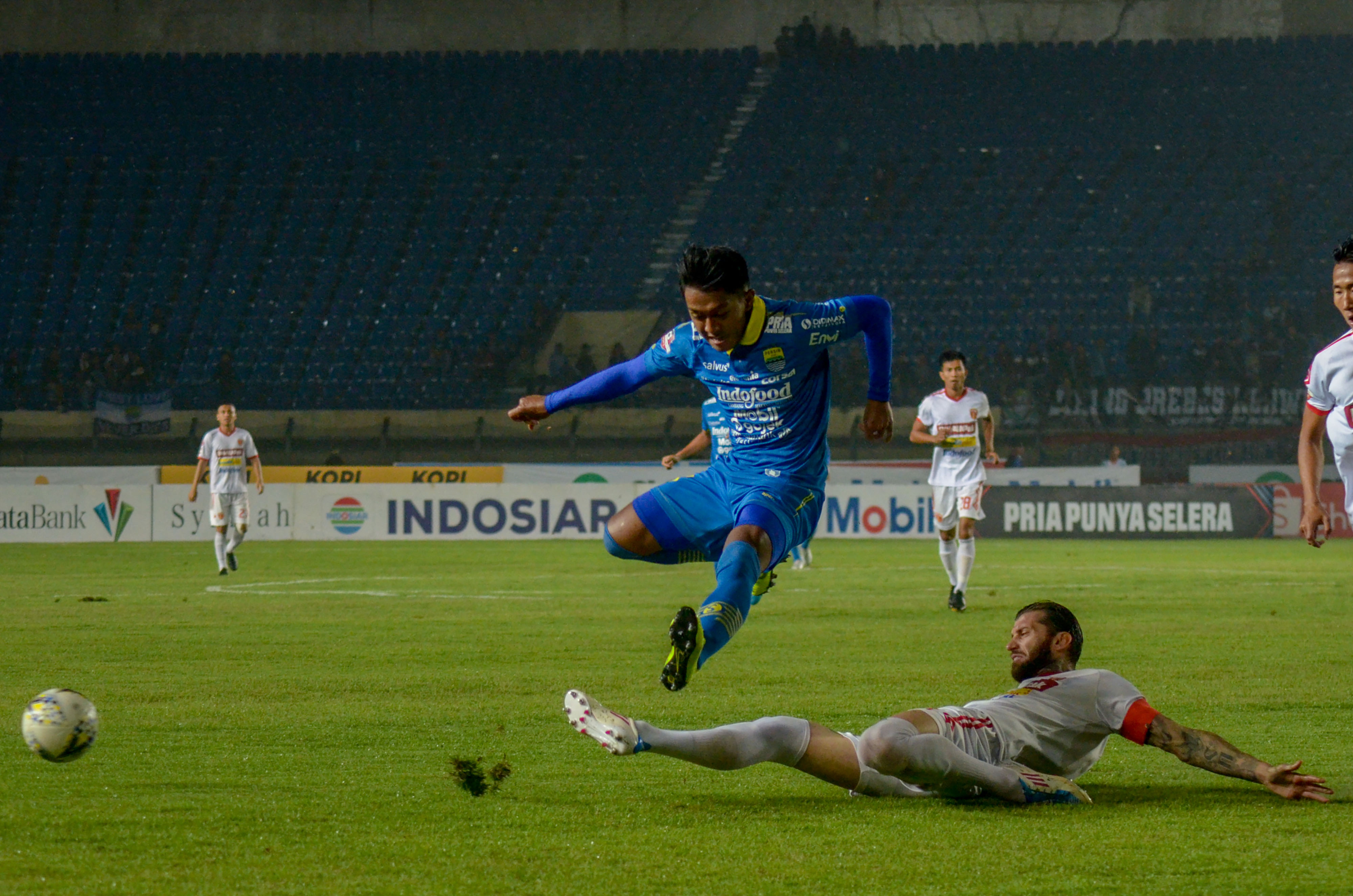Aksi pemain Persib, Febri  Hariyadi (kiri) meloncat menghindari dari jegalan pemain Perseru Bojan Malisic di laga Liga 1.