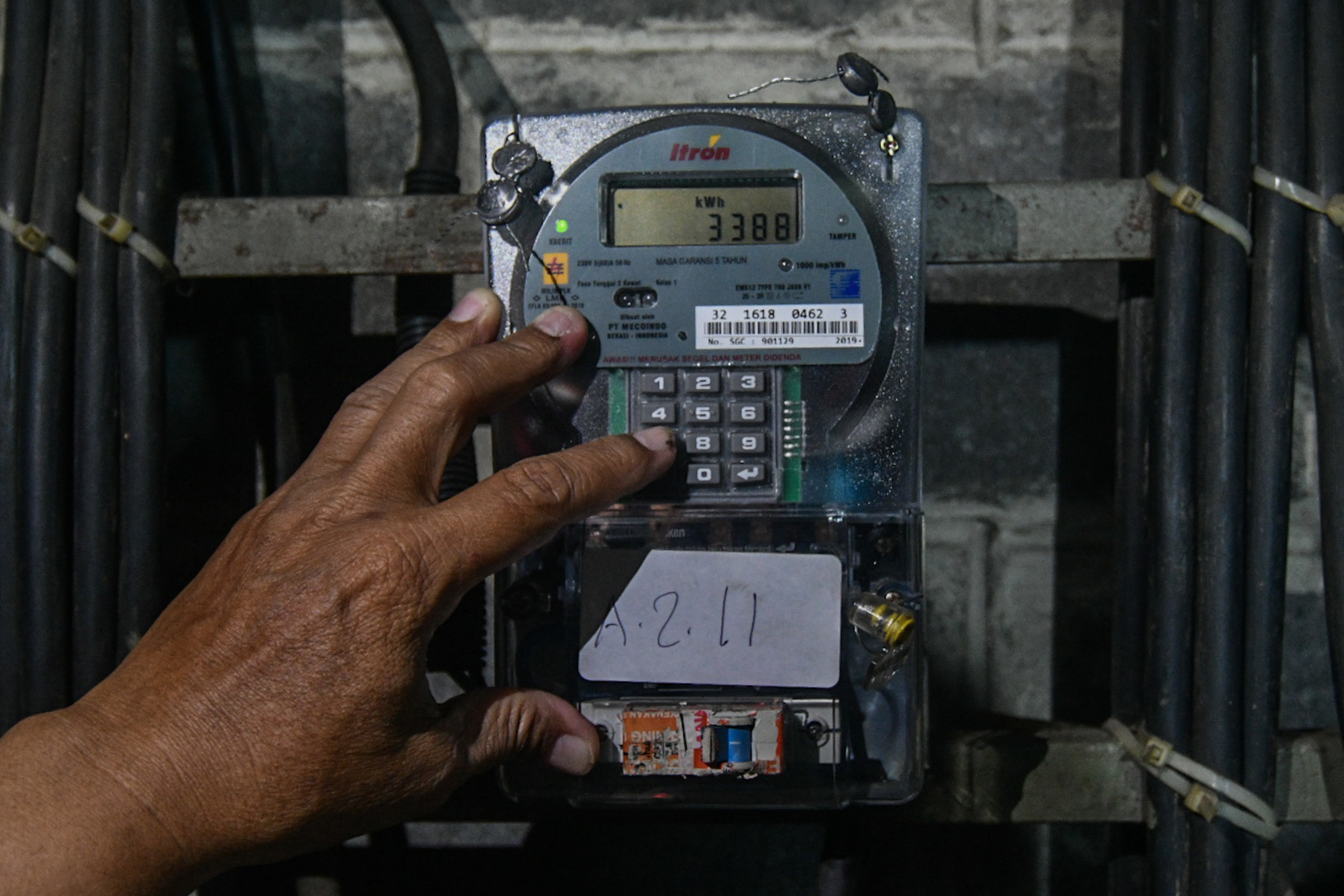 Warga memasukkan nomor token listrik PLN di kawasan rusun Jakarta.