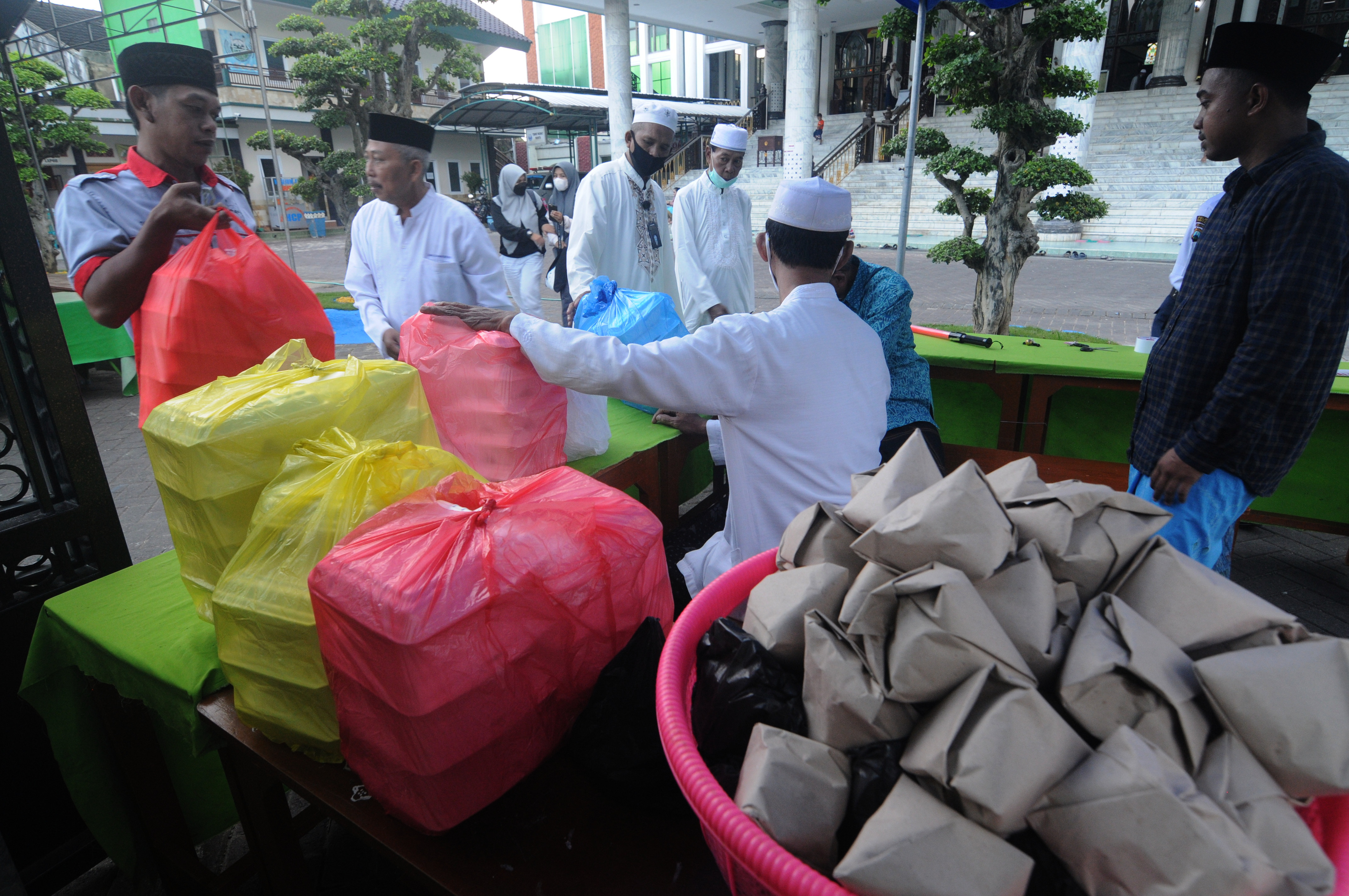 Takmir menghitung sedekah warga di Masjid Agung Asy-Syuhadak, Pamekasan, Jawa Timur, Selasa (13/4/2021)