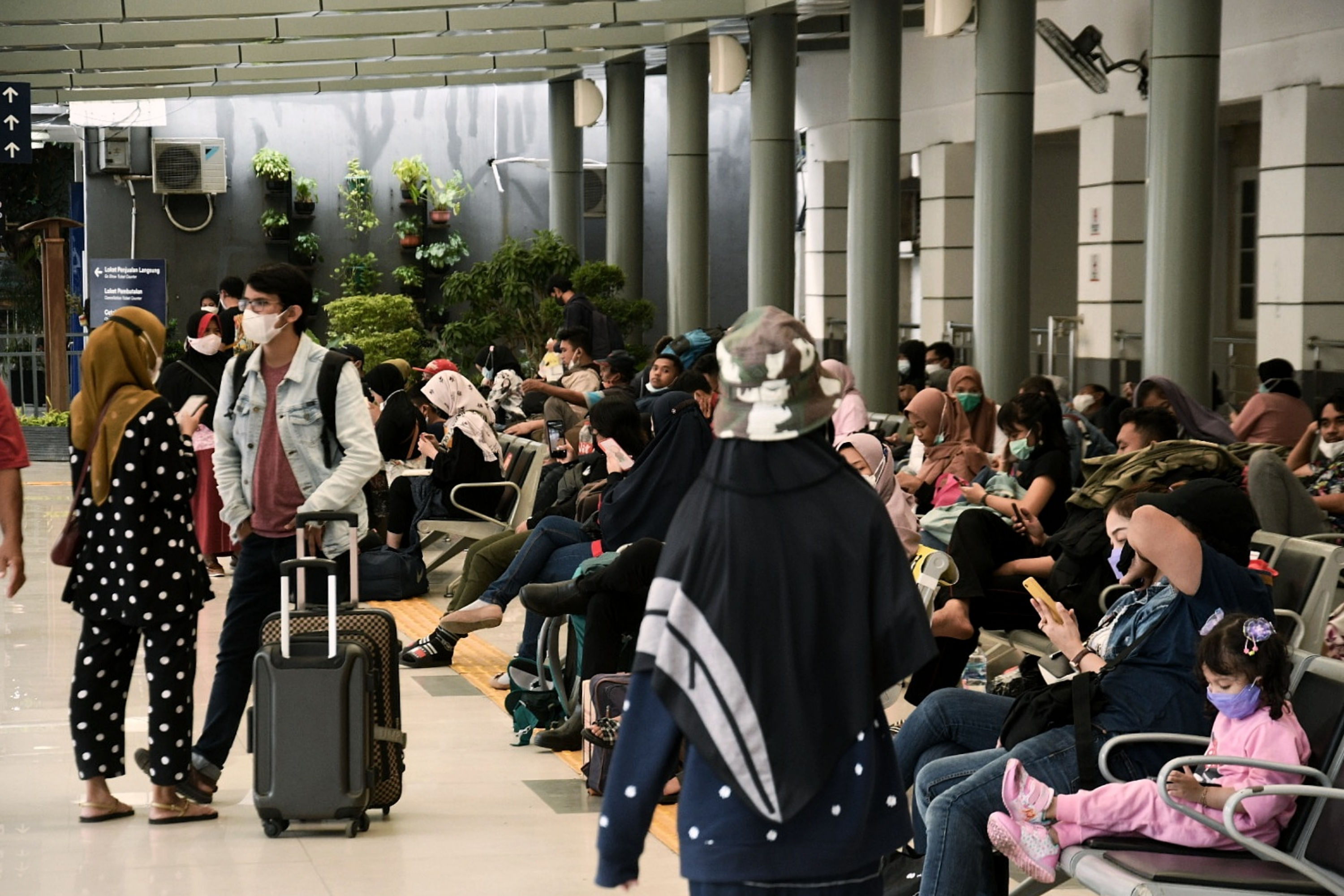 Calon penumpang menanti keberangkatan kereta yang akan dinaikinya di Stasiun Pasar Senen, Jakarta, Minggu (11/4/2021).