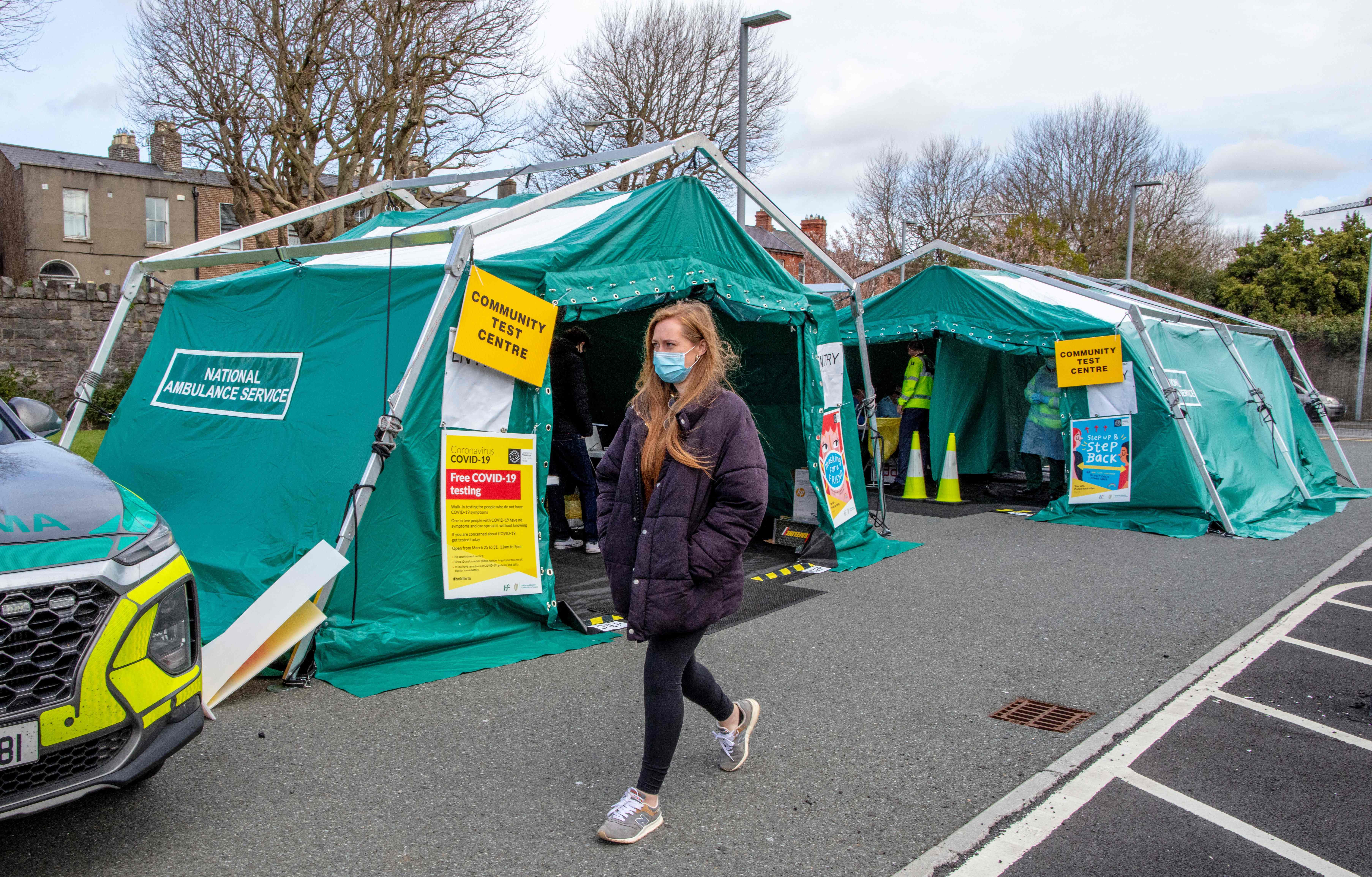 Warga melintas di depan fasilitas tes covid-19 di Dublin, Irlandia.