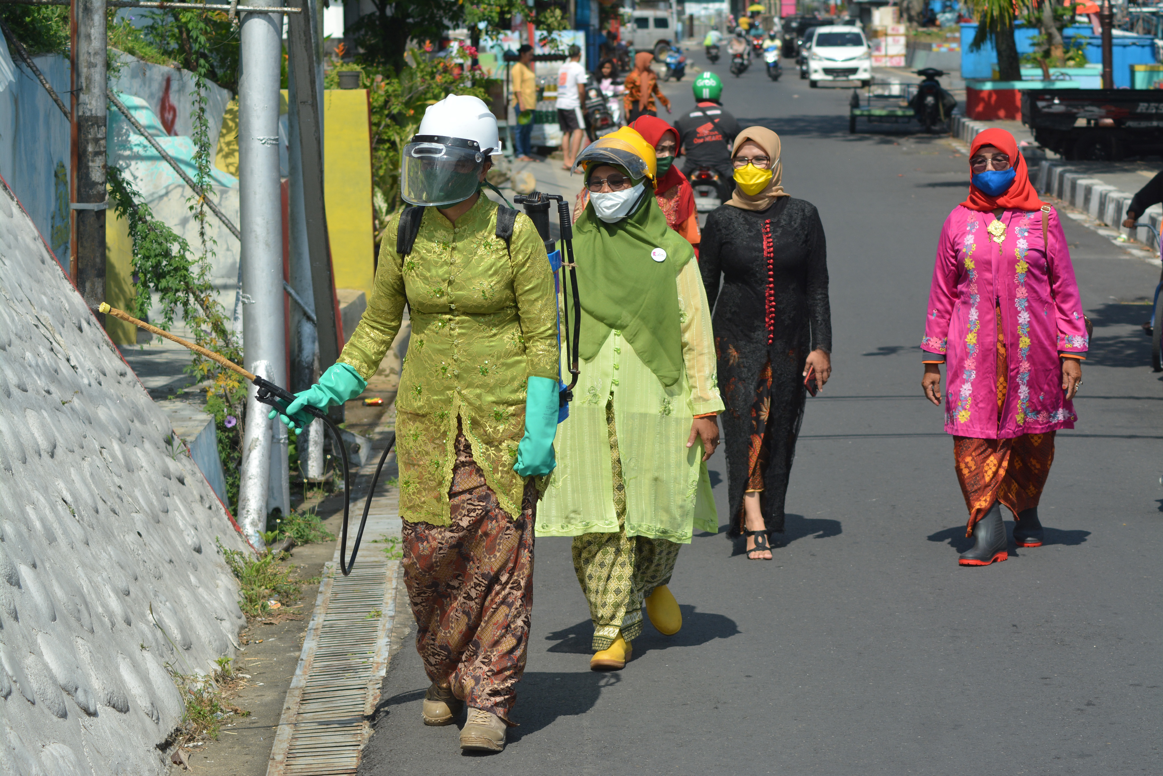Sejumlah perempuan dengan mengenakan kebaya menyemprotkan disinfektan di wilayah Padang, Sumbar.