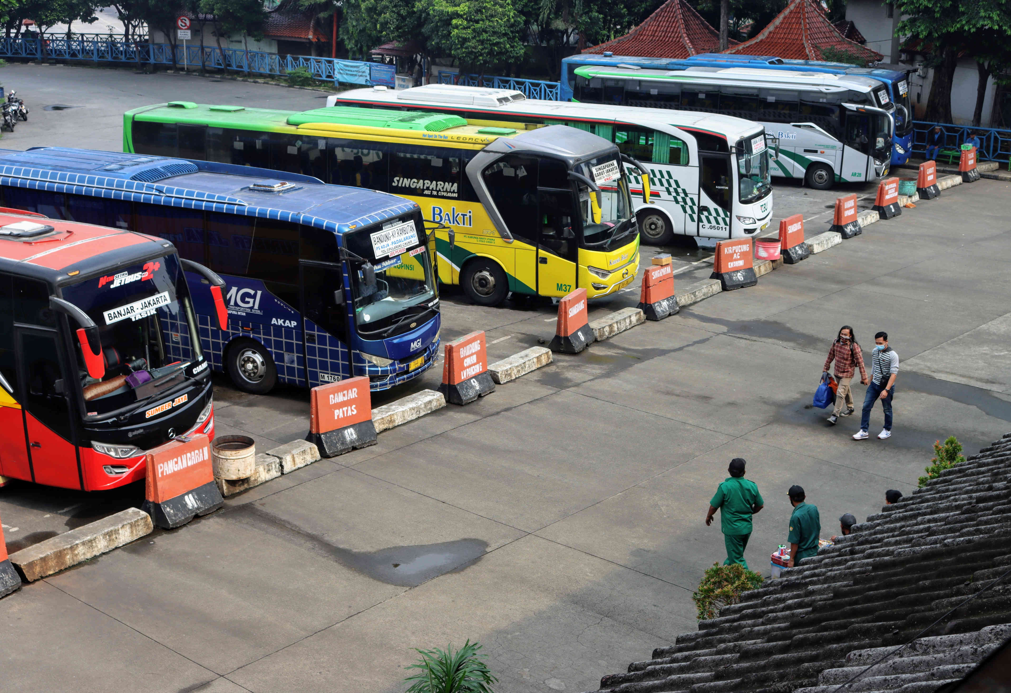 Calon penumpang berjalan menuju bus di Terminal Kampung Rambutan, Jakarta, Sabtu (27/3/2021).