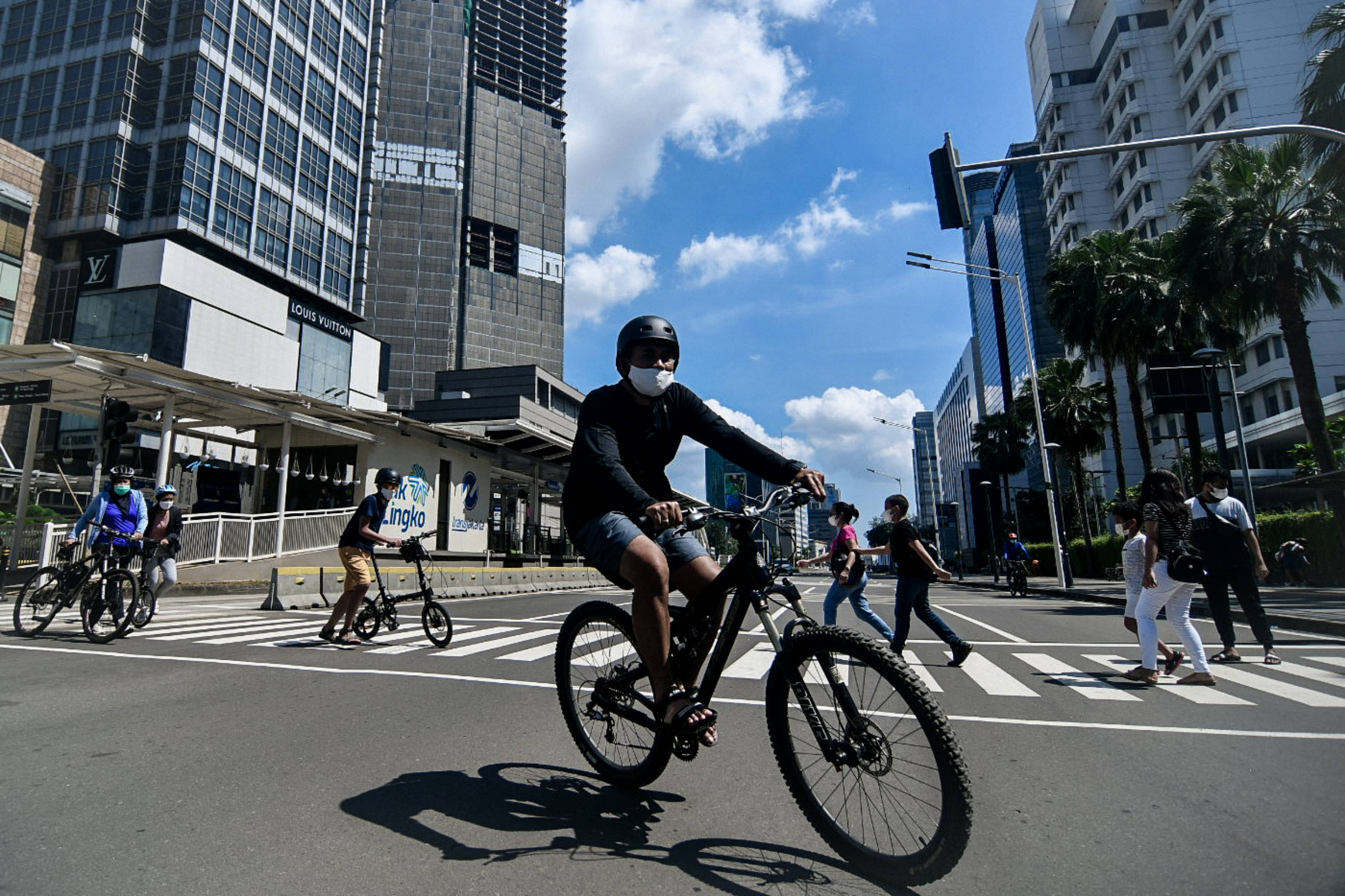  Warga bersepeda di kawasan Bundaran HI, Jakarta, Minggu (21/3/2021). 