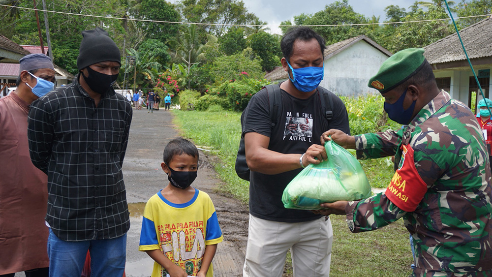 Ilustrasi Babinsa mendistribusikan bantuan sembako.