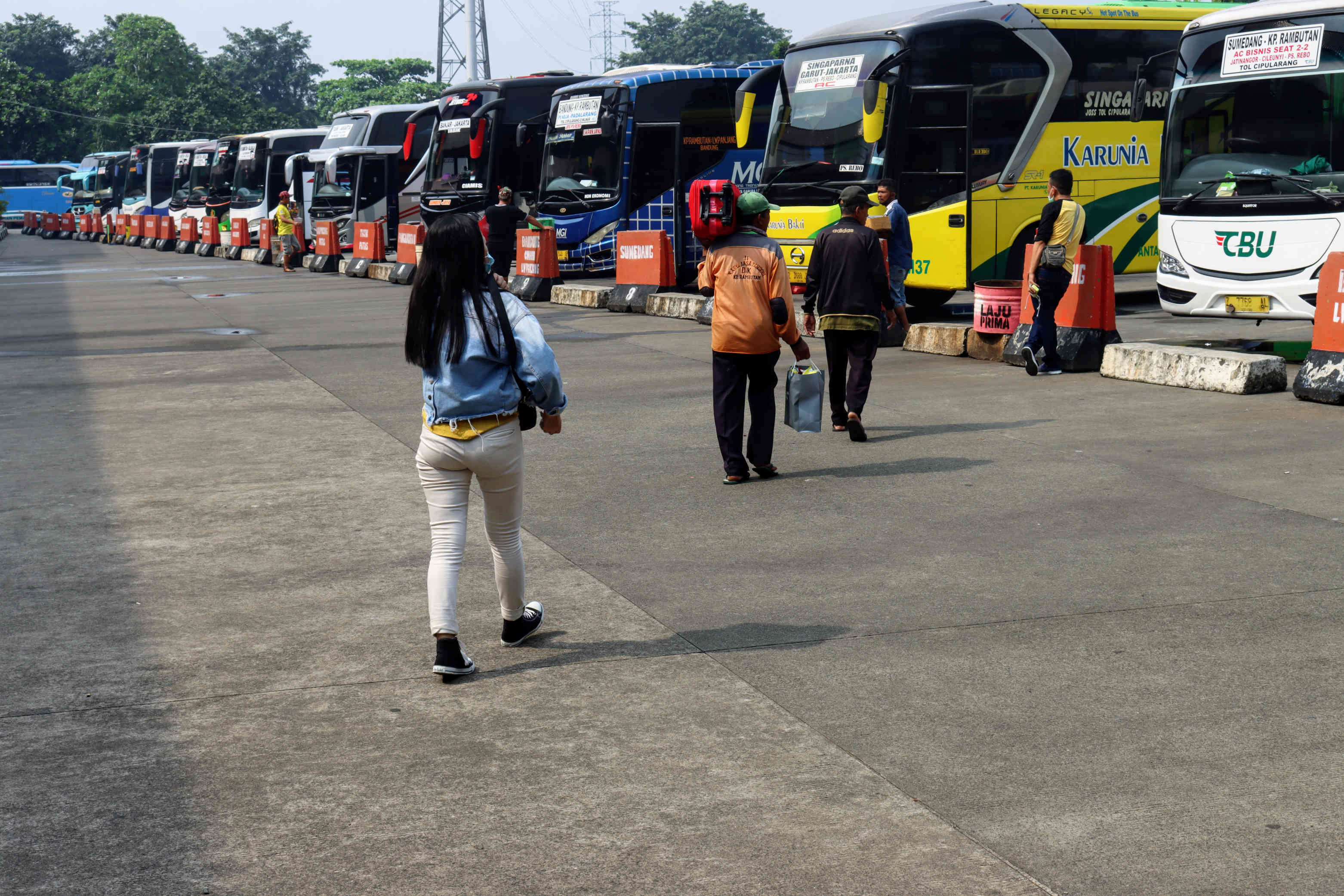 Calon penumpang berjalan menuju bus di Terminal Kampung Rambutan, Jakarta.