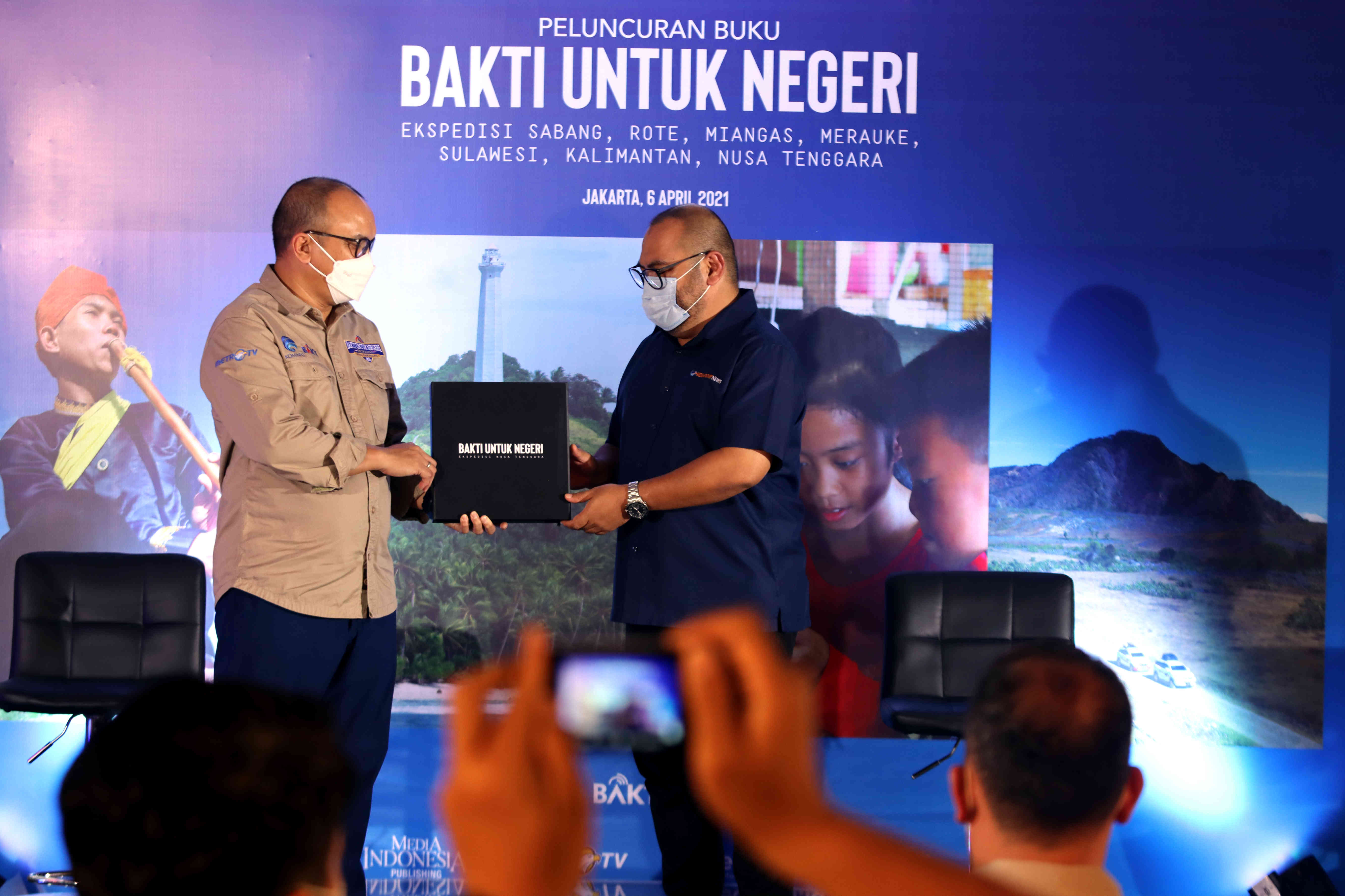 CEO Media Group Mohammad Mirdal Akib menyerahkan Buku Ekspedisi Bakti untuk Negeri kepada Dirut BAKTI Kementerian Kominfo Anang Latief