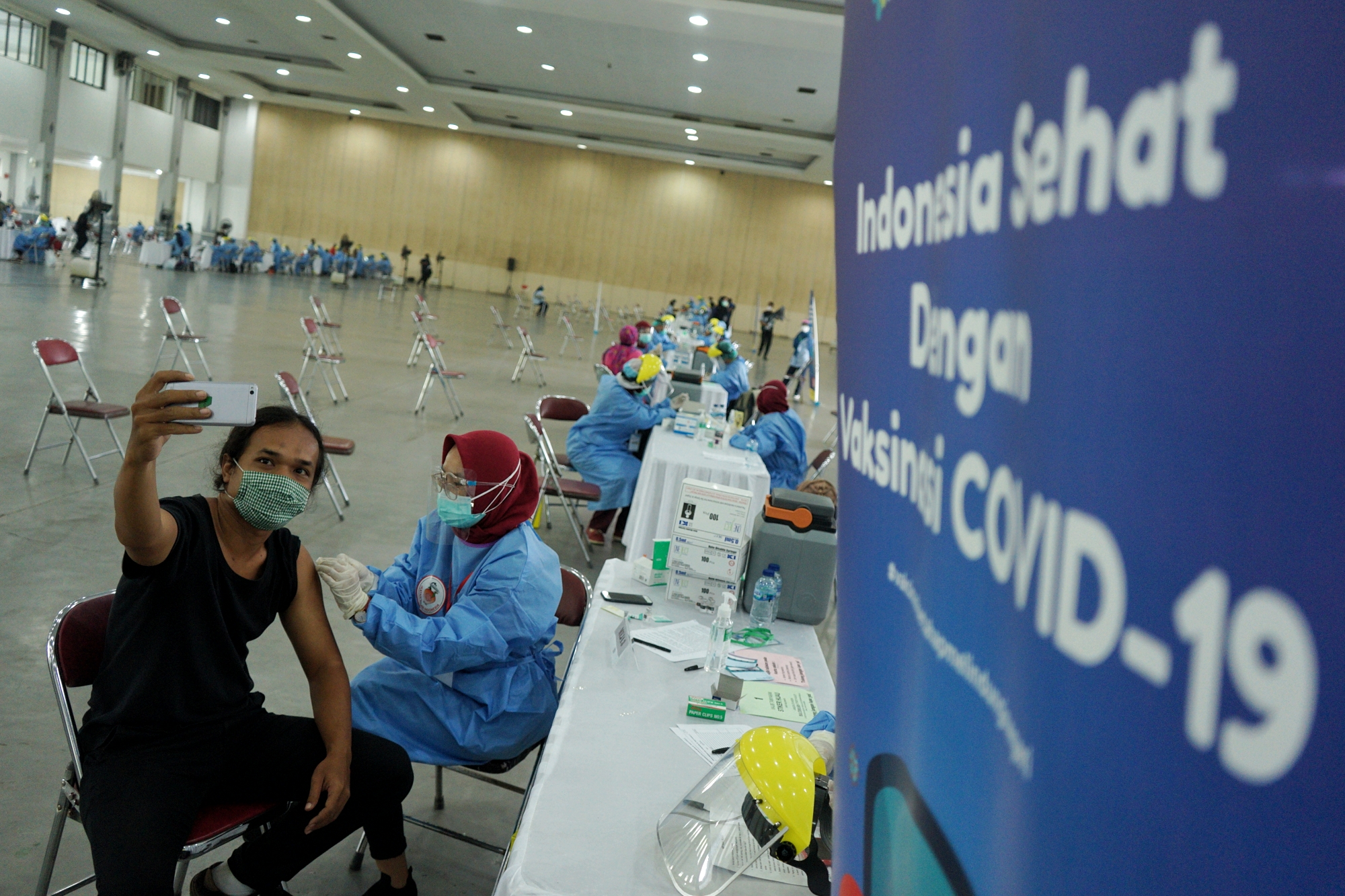 Seorang peserta berswa foto saat mendapat vaksinasi COVID-19 dosis kedua di Jogja Expo Centre, Bantul, D.I Yogyakarta, Selasa (30/3/2021).