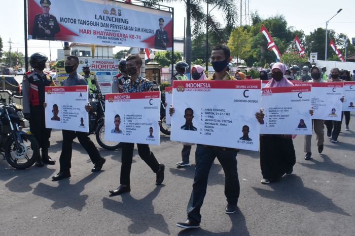 Sejumlah warga menerima SIM secara simbolis. Polri kini membuka layanan pembuatan dan perpanjangan SIM secara digital.