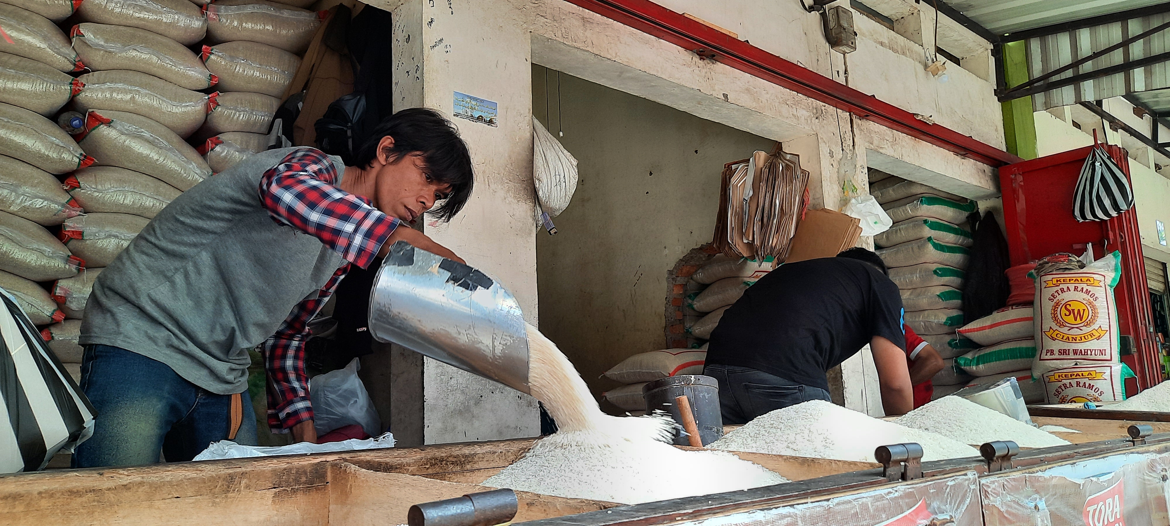 Pedagang menuangkan beras di Di Pasar Induk Cianjur, Jawa Barat, Minggu (04/4). Stok beras cukup selama bulan Ramadan dan Idul Fitri.