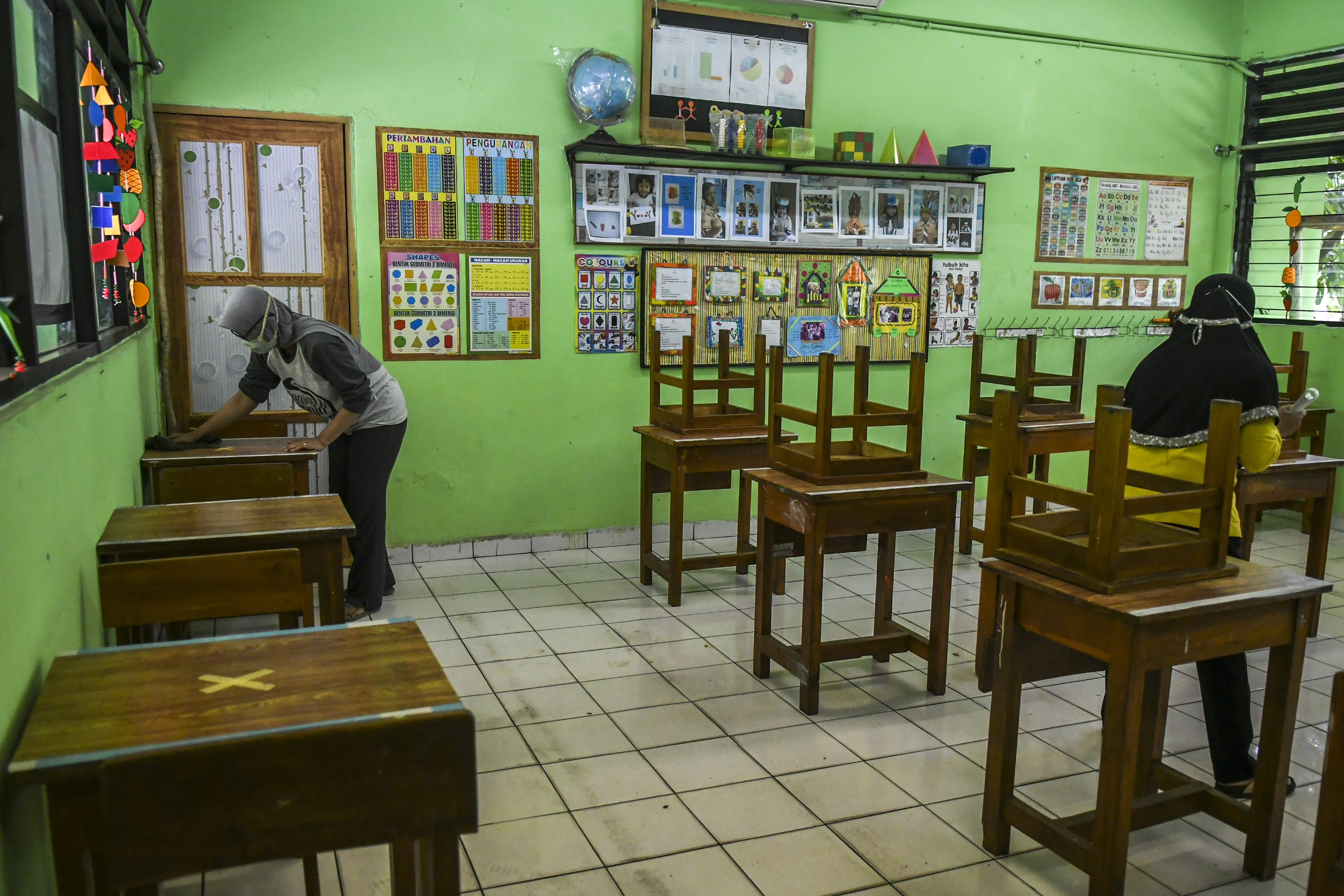  Guru merapikan ruang kelas di SD Kenari 08 Pagi, Jakarta, Selasa (6/4/2021). Pemprov DKI akan melakukan uji coba pembelajaran tatap muka.