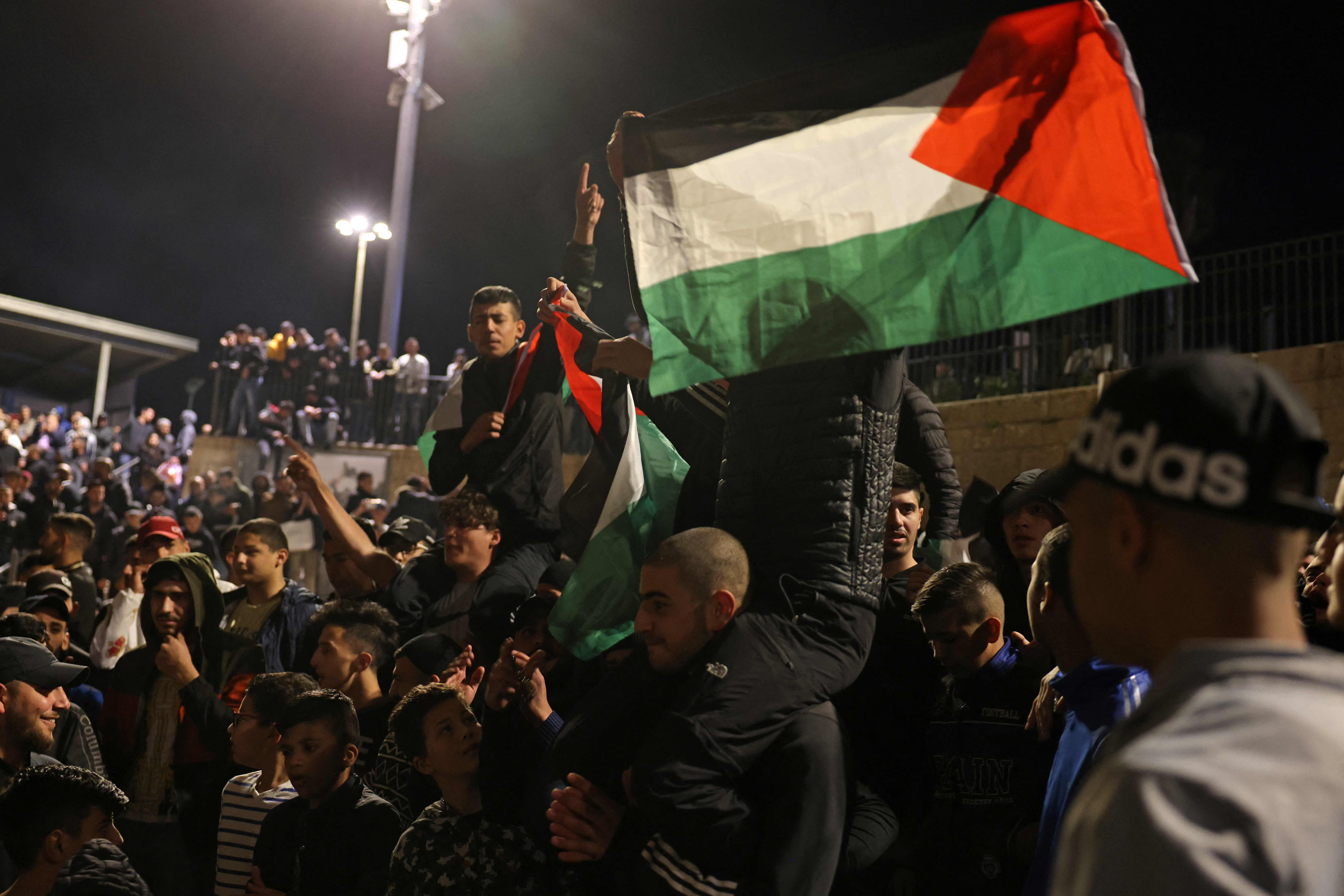 Warga Palestina mengibarkan bendera nasional di luar Gerbang Damaskus di Kota Tua Yerusalem, Selasa (27/4). 
