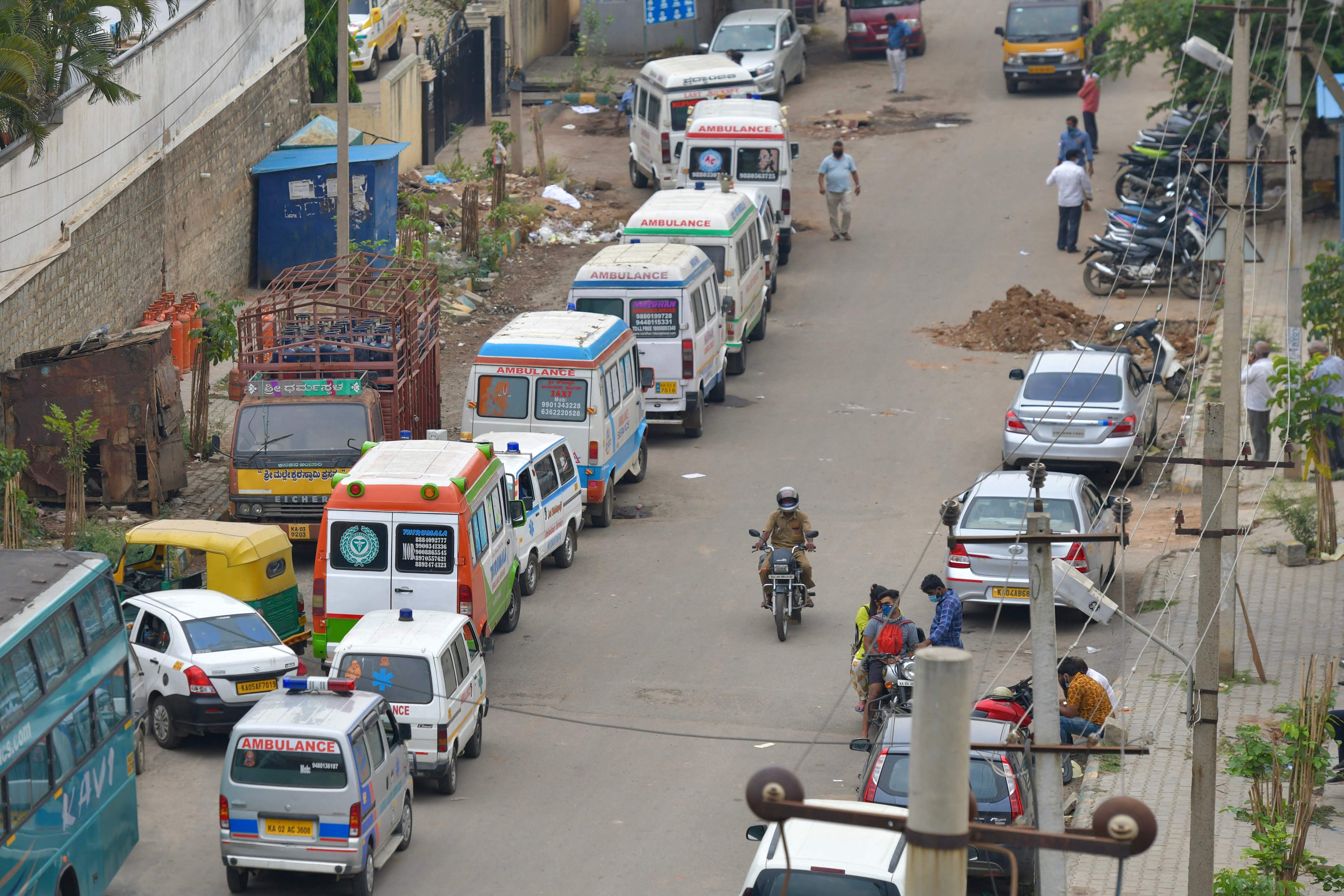 Ambulans yang mengakut jenazah pasien covid-19 mengantre di sebuah krematorium di Bangalore, India.