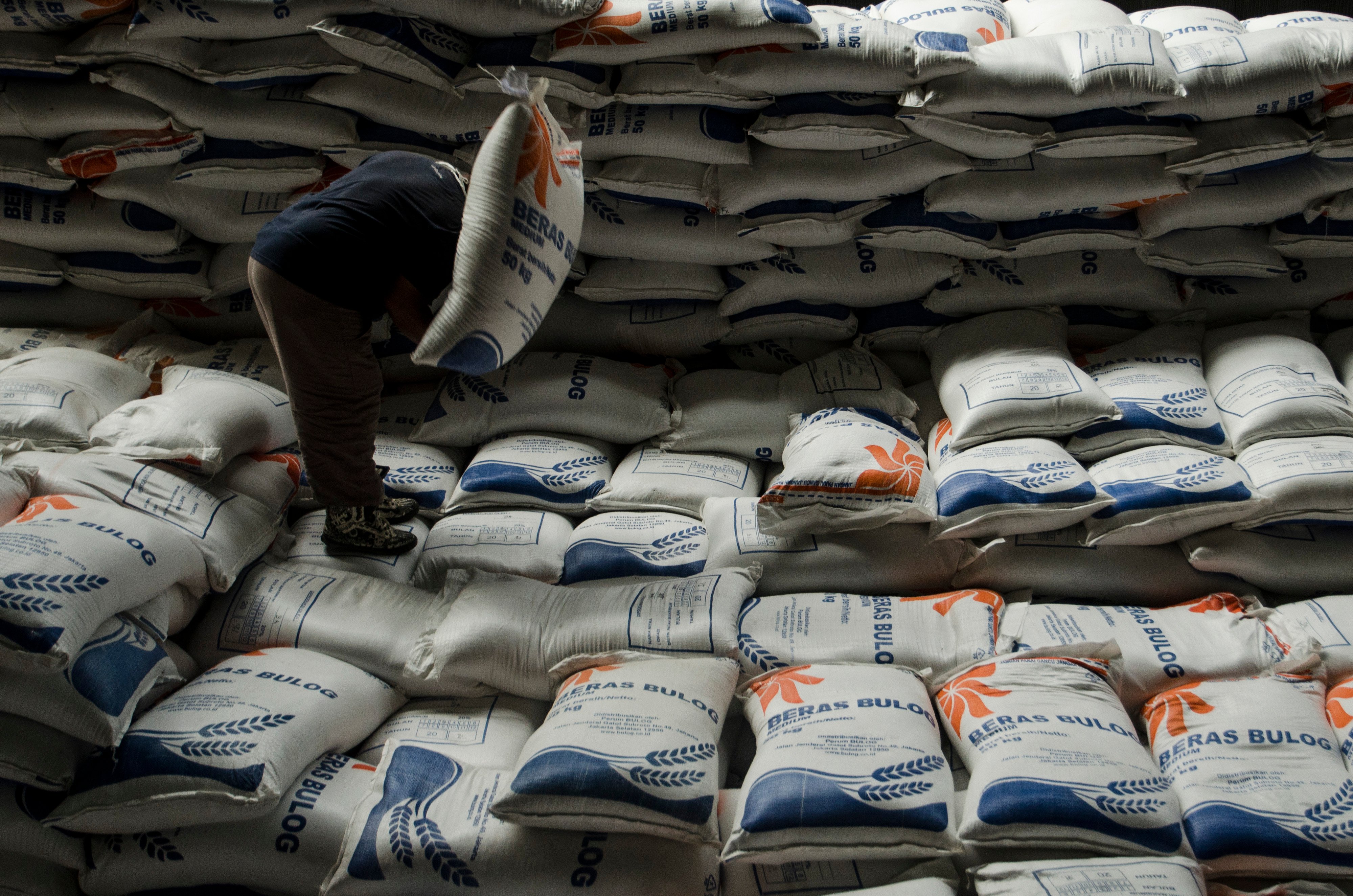 Pekerja mengangkat stok beras di gudang pangan Komplek Pergudangan Bulog, Bandung, Jawa Barat