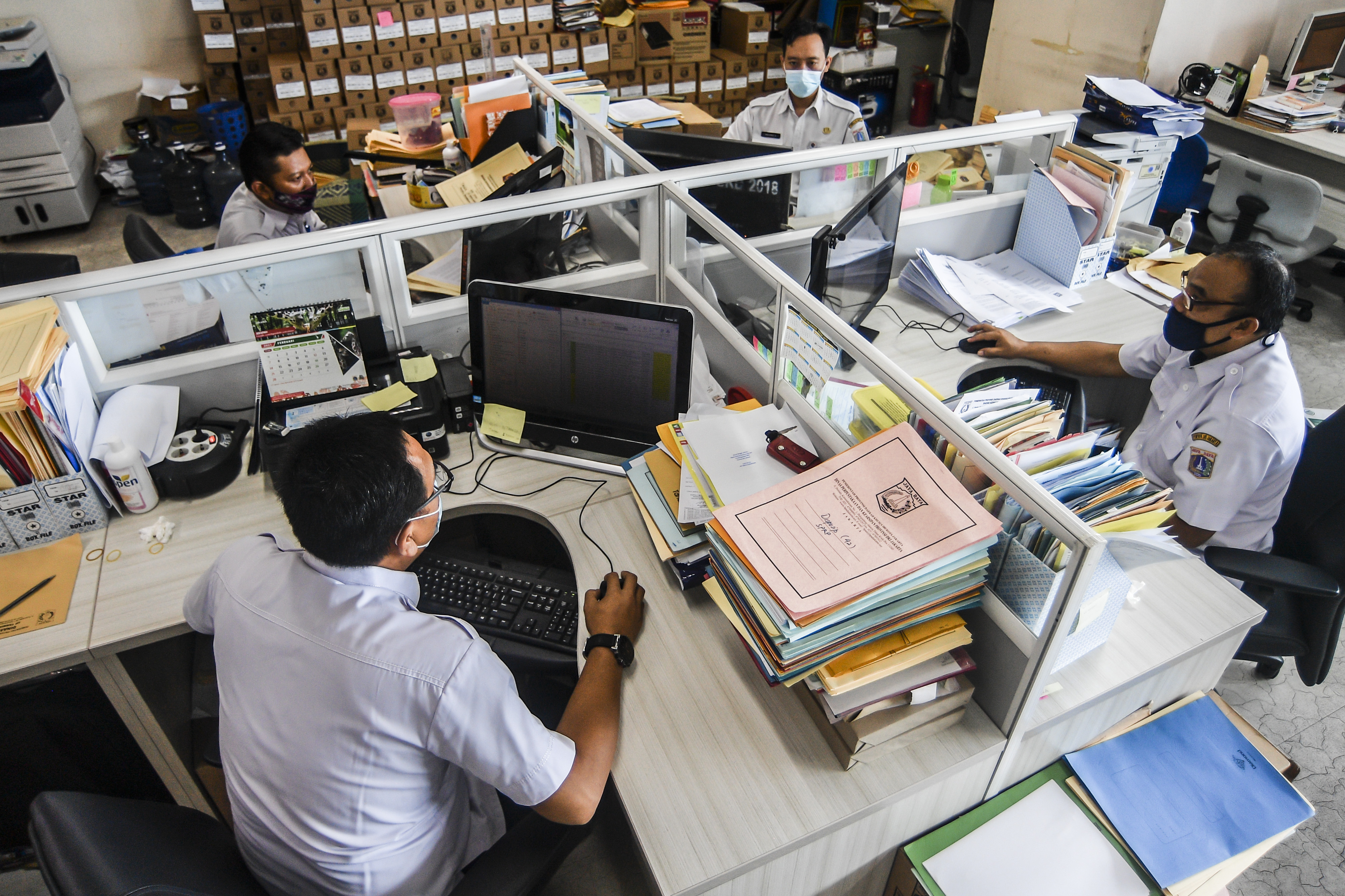 Pegawai Badan Kepegawaian Daerah DKI Jakarta menyelesaikan pekerjaannya di kantor Balai kota Jakarta.