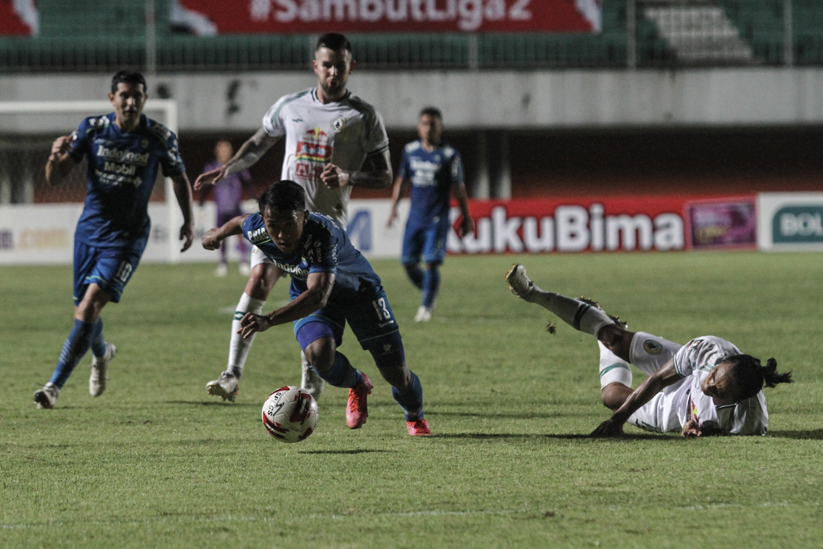 Pesepak bola Persib Bandung Febri Hariyadi (tengah) mencoba melewati pesepak bola PSS Sleman Kim Kurniawan (kanan)